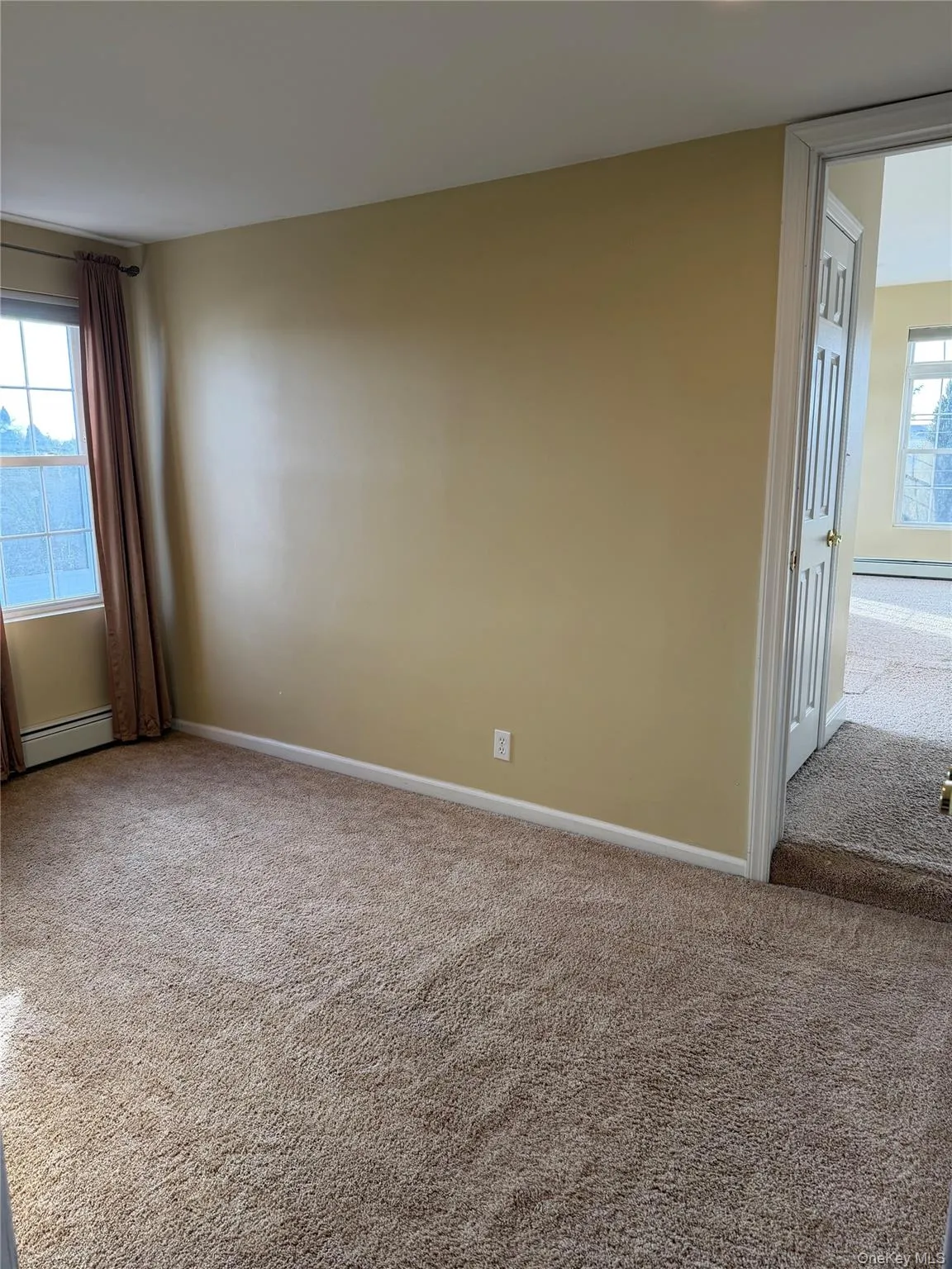 Carpeted spare room featuring a baseboard heating unit Carpeted spare room featuring a baseboard heating unit