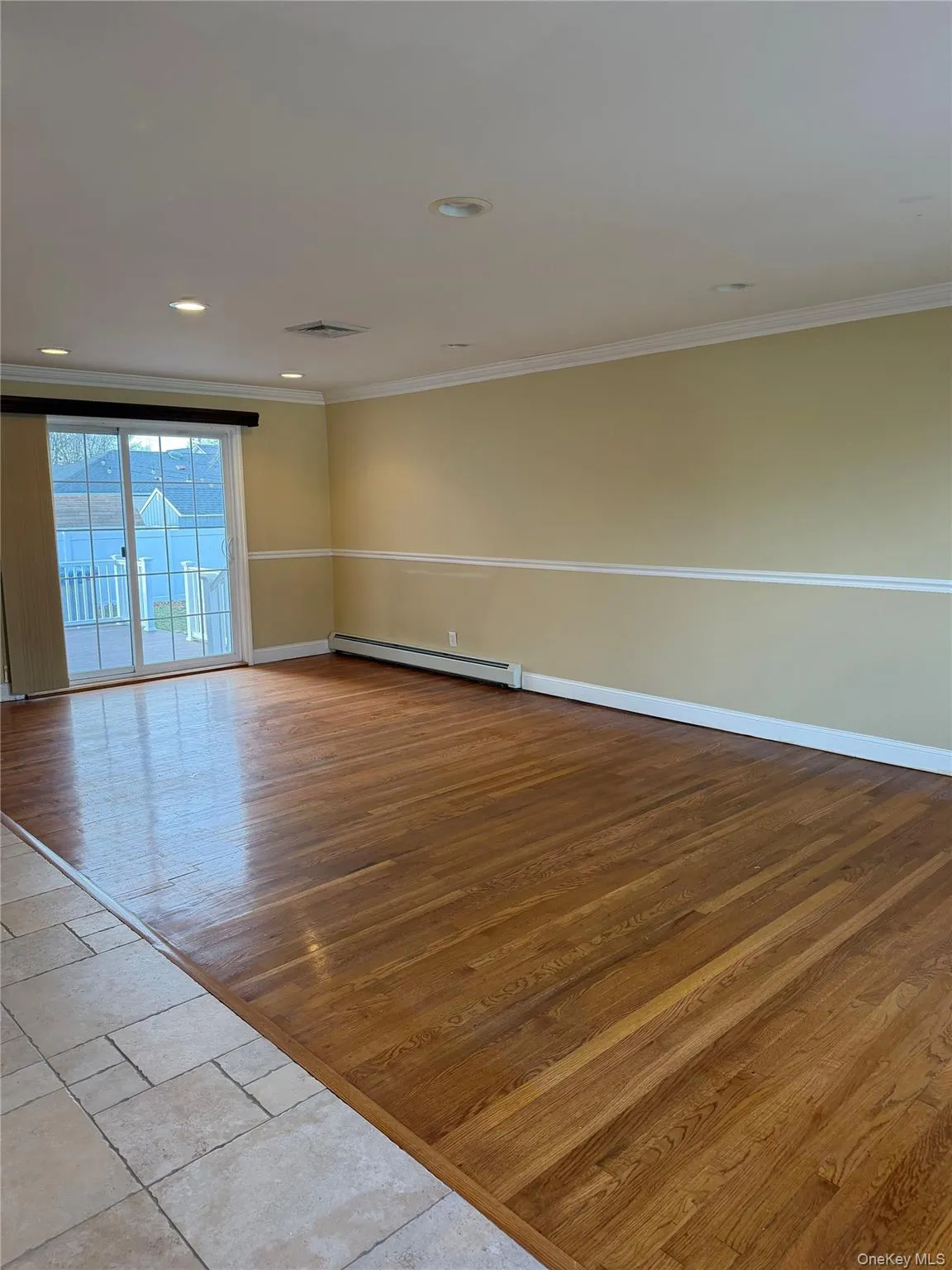 Unfurnished room featuring light wood finished floors, a baseboard heating unit, crown molding, and recessed lighting Unfurnished room featuring light wood finished floors, a baseboard heating unit, crown molding, and recessed lighting