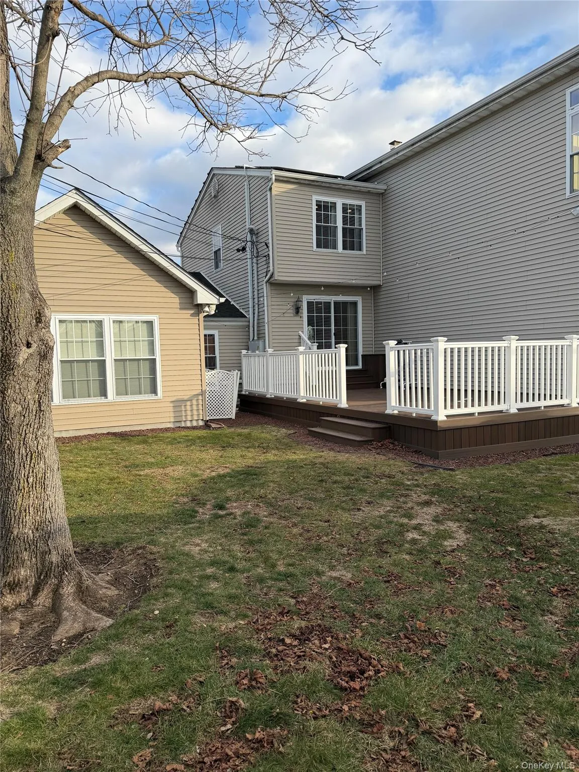 Rear view of property with a wooden deck and a lawn Rear view of property with a wooden deck and a lawn
