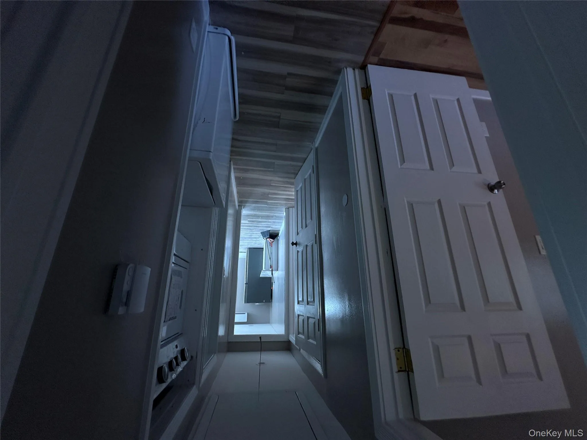 Corridor featuring attic access, dark wood-style flooring, and washer / dryer Corridor featuring attic access, dark wood-style flooring, and washer / dryer