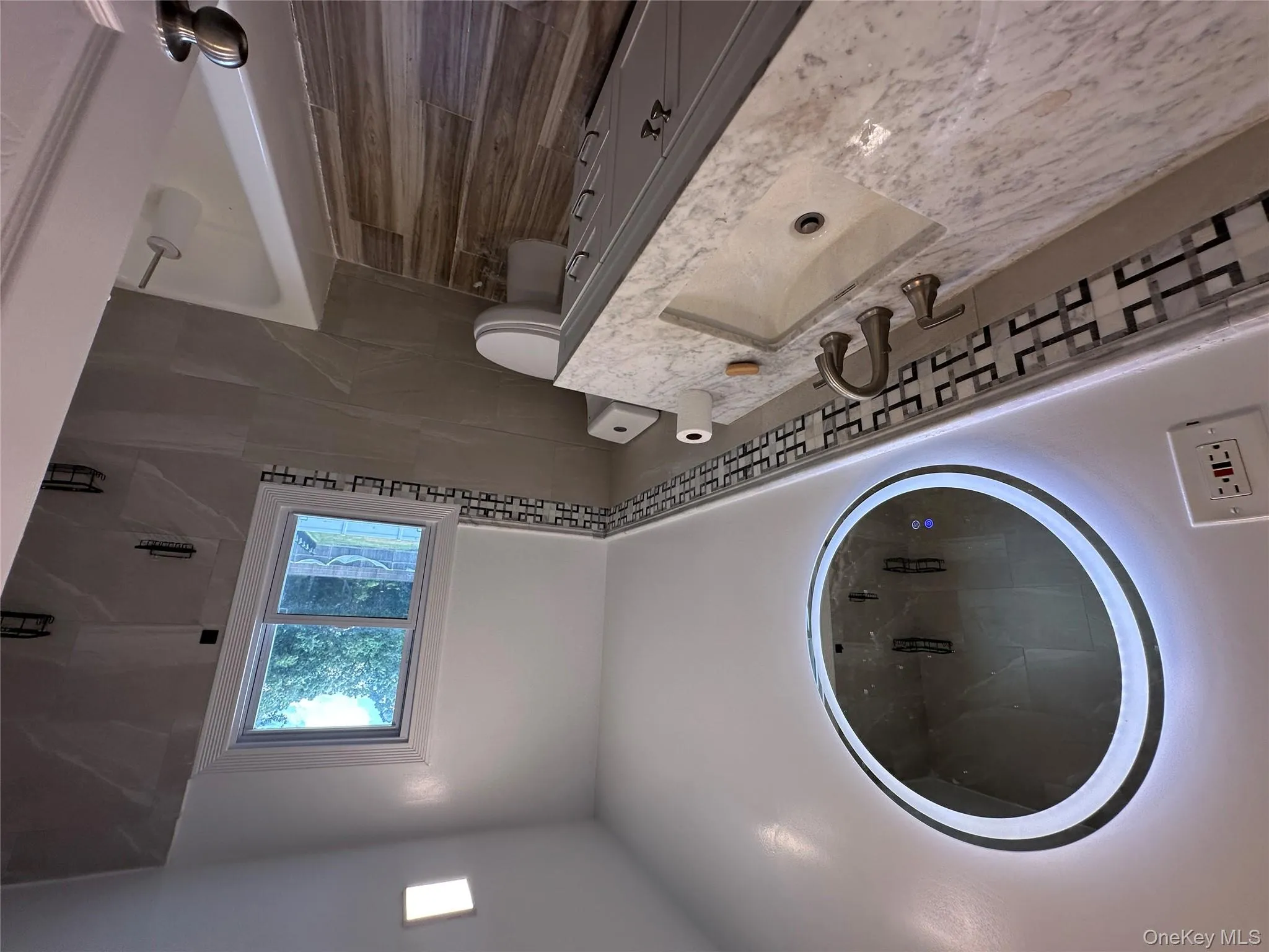 Bathroom with vanity, a bathtub, wainscoting, a shower, and tile walls Bathroom with vanity, a bathtub, wainscoting, a shower, and tile walls