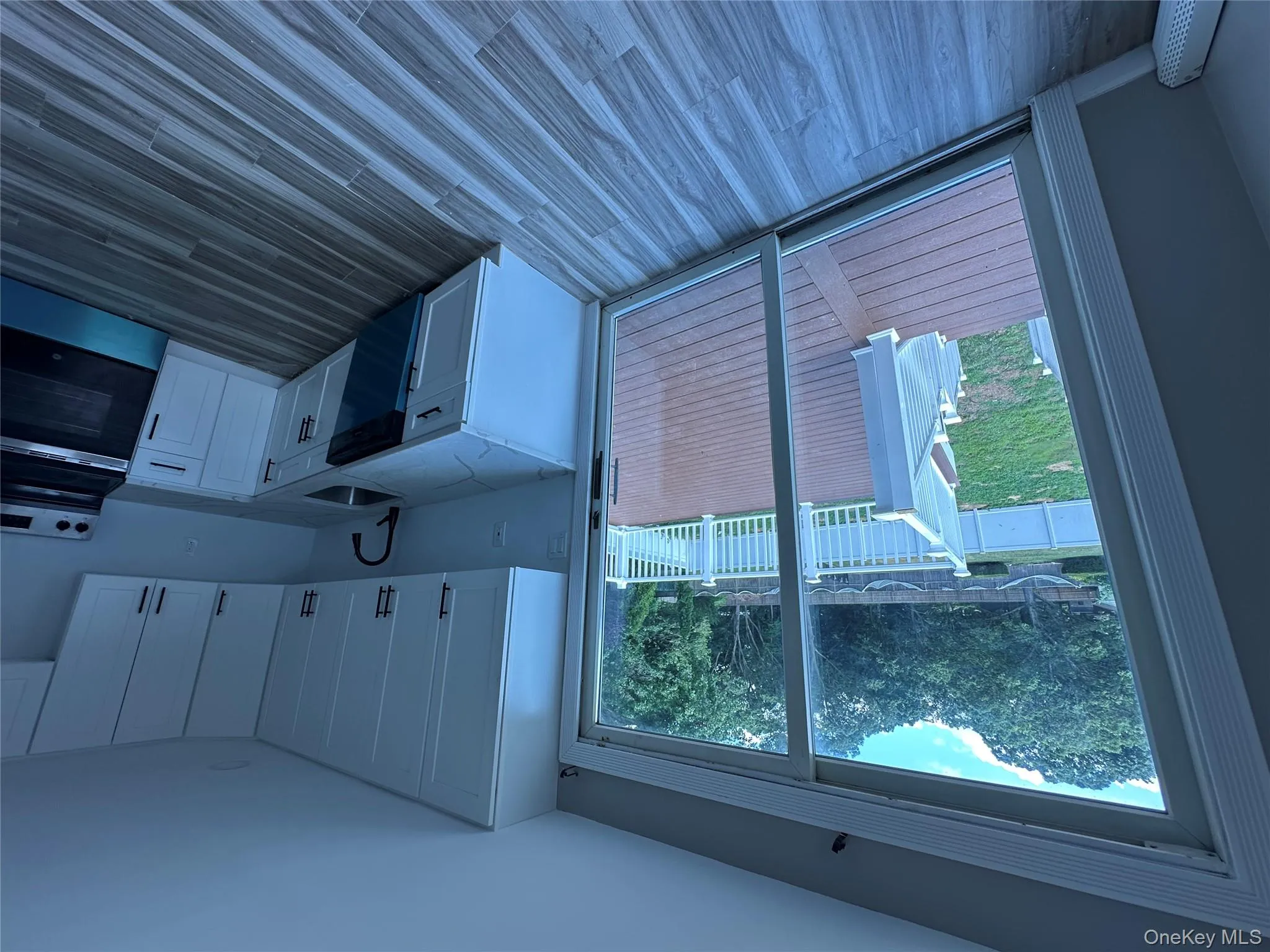 Kitchen with white cabinetry, range, light stone countertops, dishwashing machine, and dark wood-type flooring Kitchen with white cabinetry, range, light stone countertops, dishwashing machine, and dark wood-type flooring