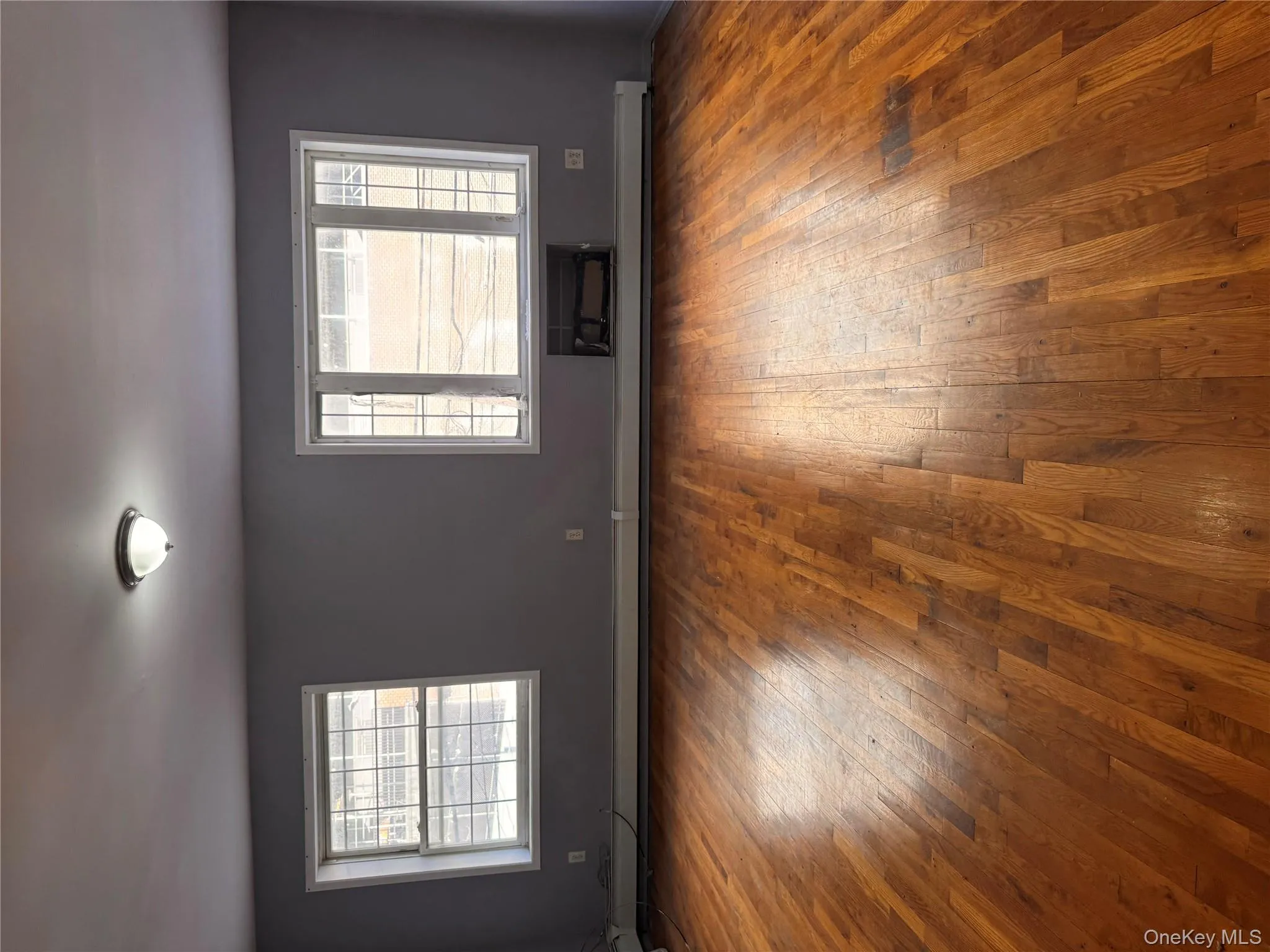 Spare room with healthy amount of natural light and hardwood / wood-style flooring Spare room with healthy amount of natural light and hardwood / wood-style flooring