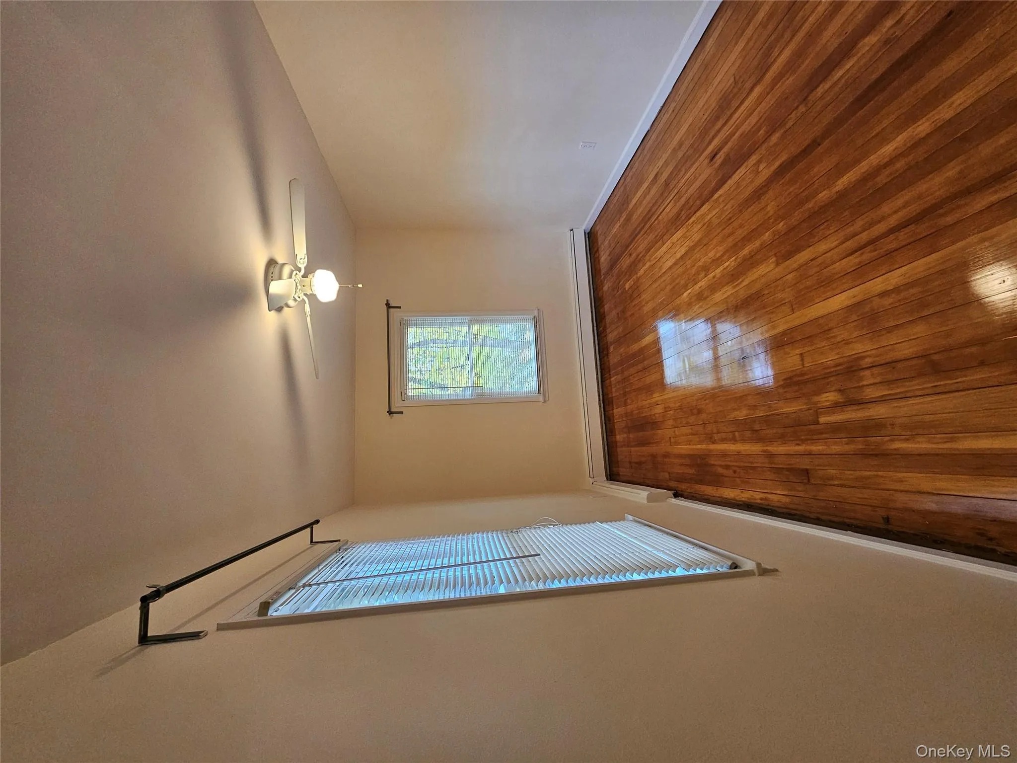 Empty room featuring hardwood / wood-style floors, baseboard heating, and a ceiling fan Empty room featuring hardwood / wood-style floors, baseboard heating, and a ceiling fan