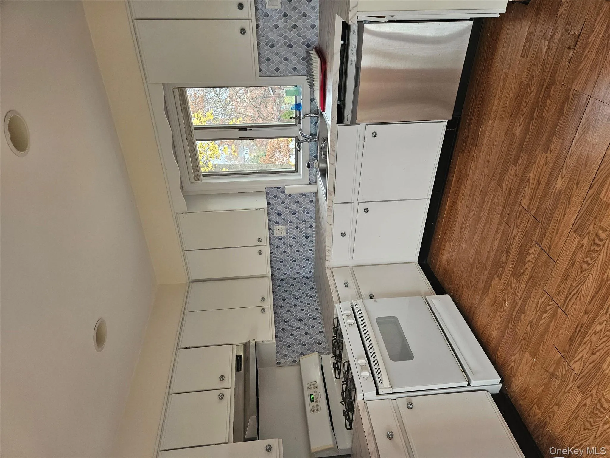 Kitchen with range, light countertops, dishwasher, and white cabinets Kitchen with range, light countertops, dishwasher, and white cabinets