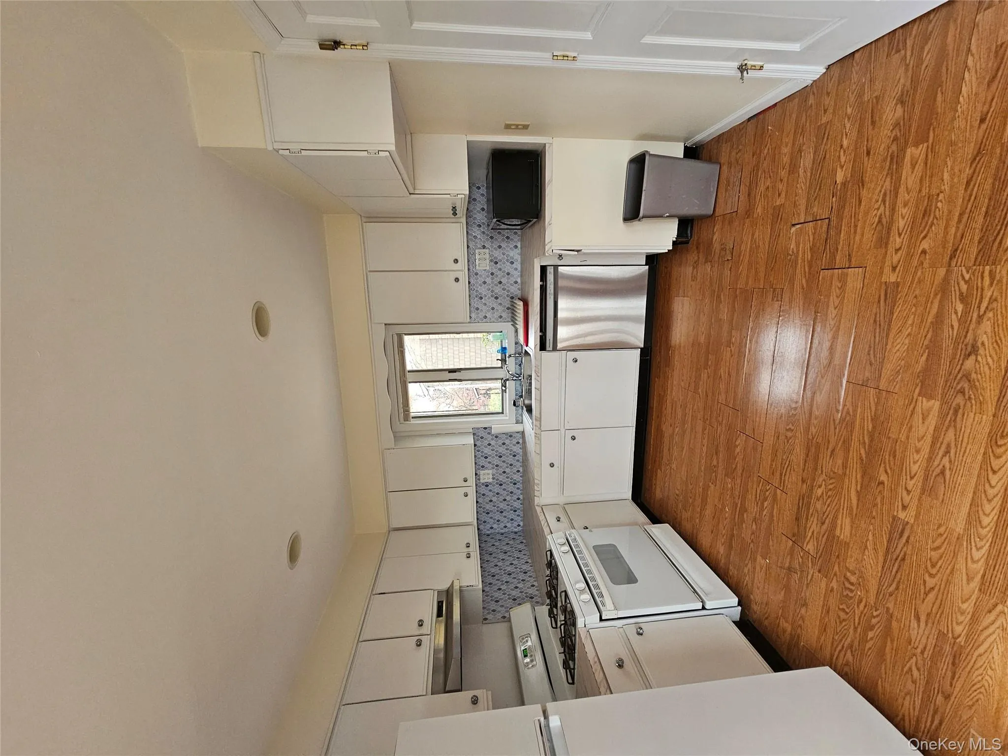 Kitchen with range, light countertops, and white cabinetry Kitchen with range, light countertops, and white cabinetry