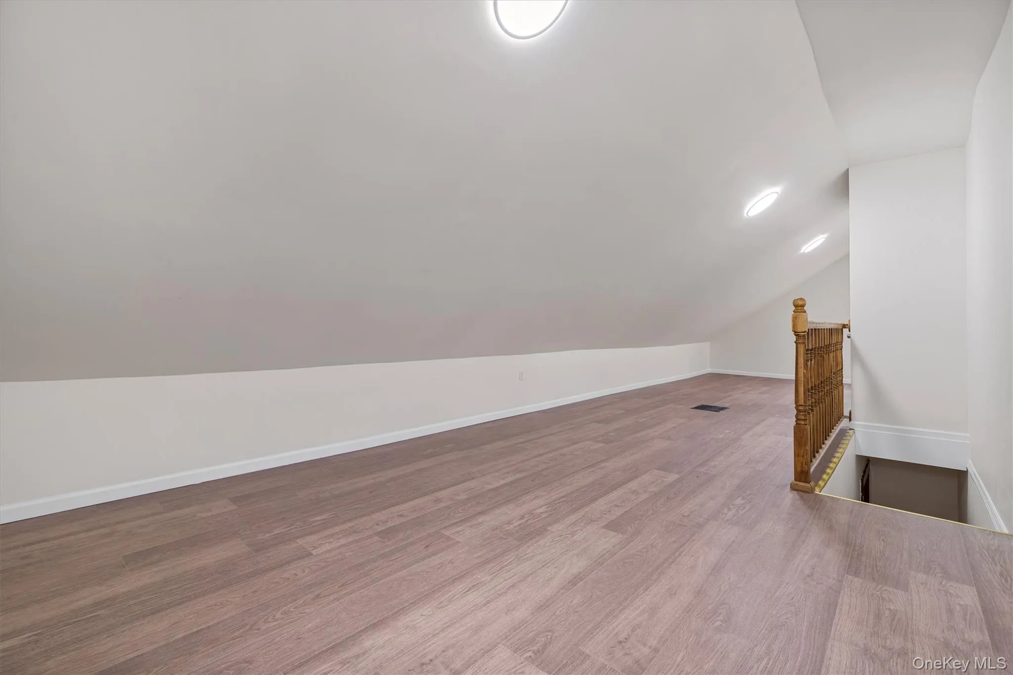 Bonus room with vaulted ceiling and wood finished floors Bonus room with vaulted ceiling and wood finished floors