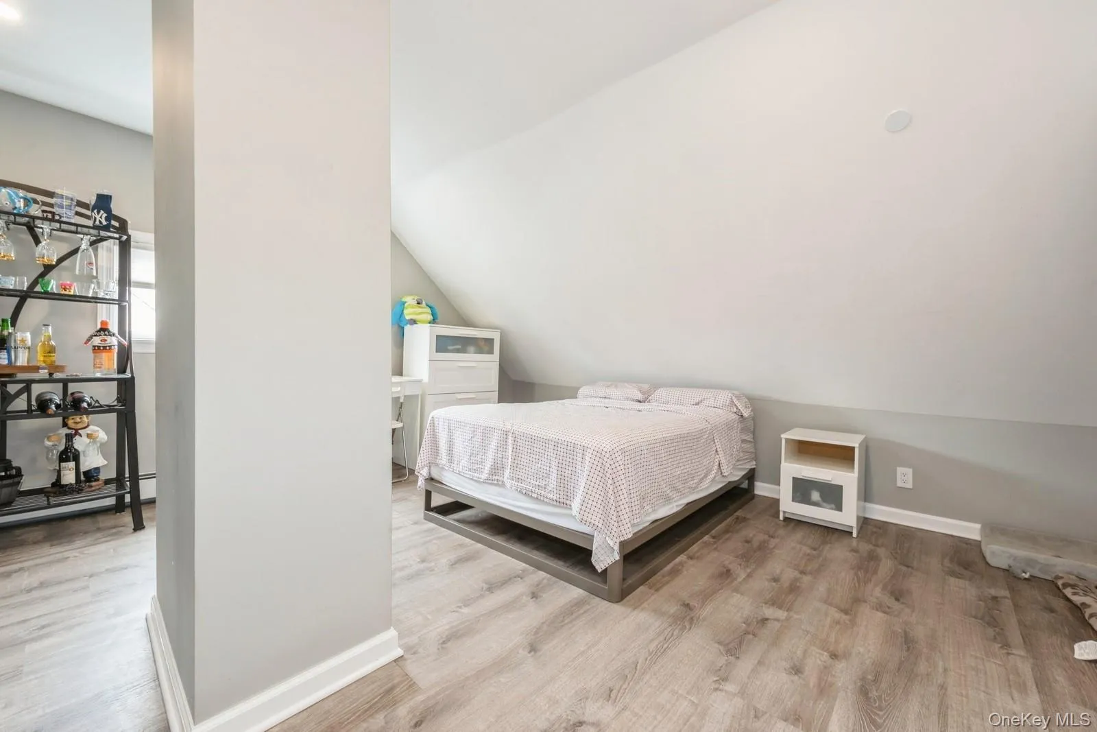 Bedroom with light wood finished floors and vaulted ceiling Bedroom with light wood finished floors and vaulted ceiling
