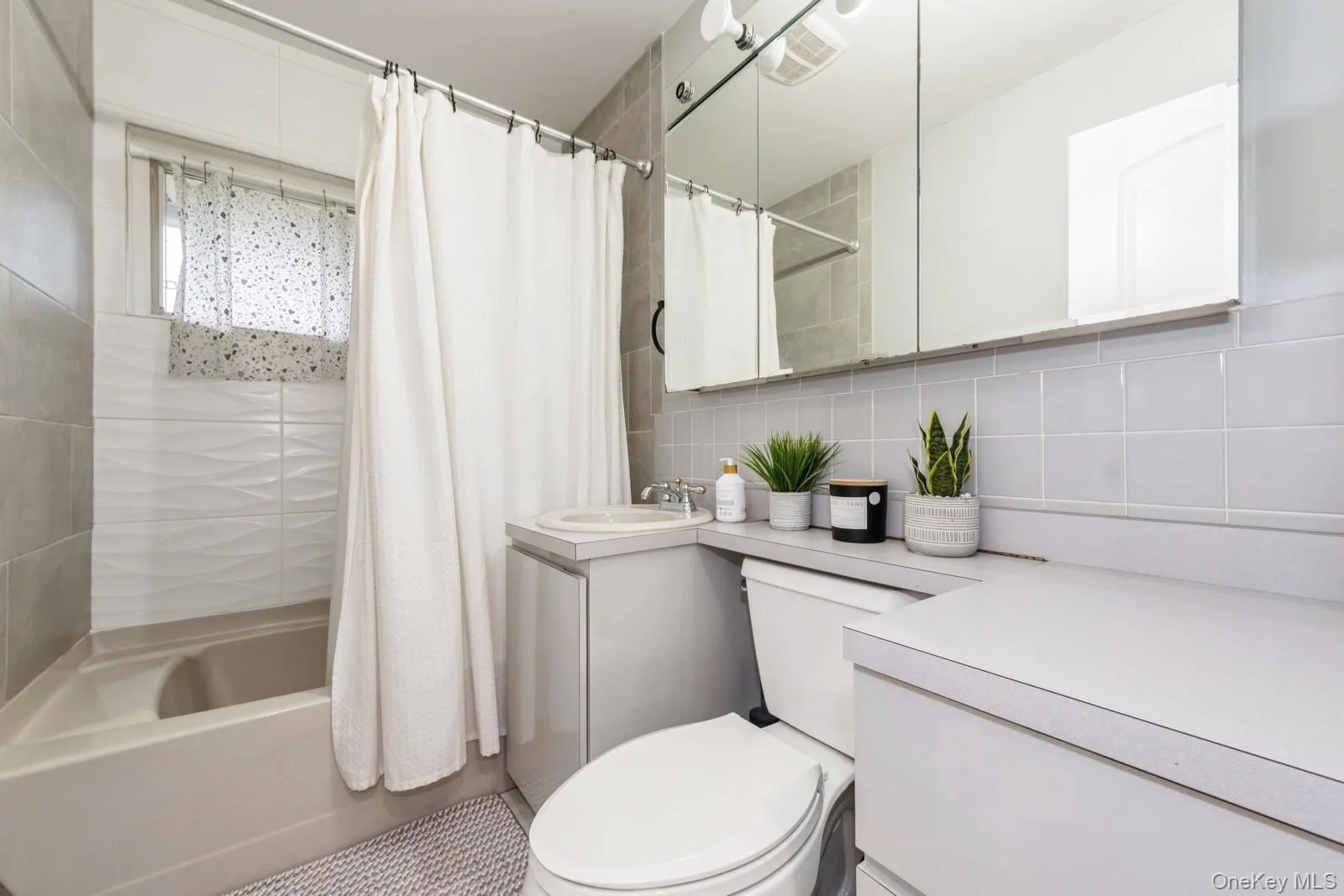 Full bathroom with vanity, shower / bath combo with shower curtain, and decorative backsplash Full bathroom with vanity, shower / bath combo with shower curtain, and decorative backsplash