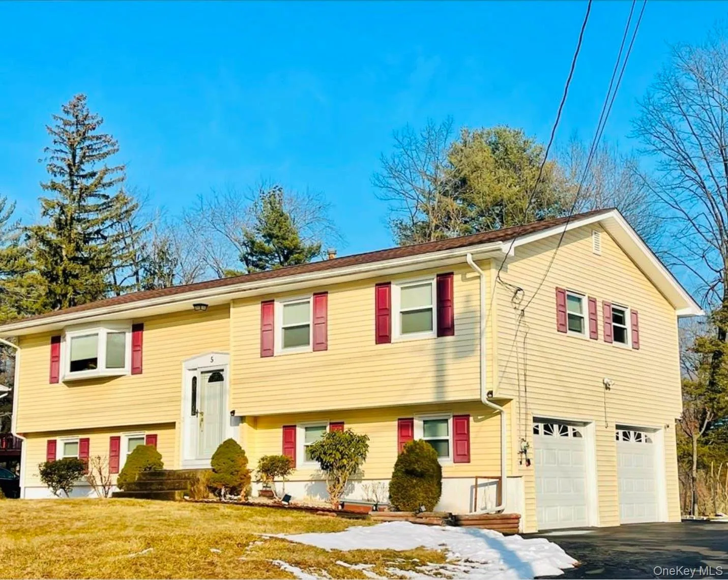 Raised ranch featuring a garage and asphalt driveway Raised ranch featuring a garage and asphalt driveway