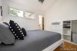 Bedroom with high vaulted ceiling and wood finished floors Bedroom with high vaulted ceiling and wood finished floors