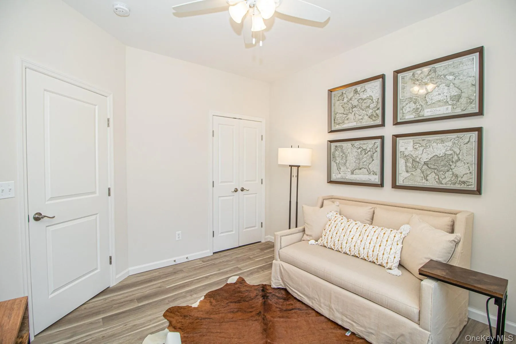 Sitting room with light wood-style flooring and a ceiling fan Sitting room with light wood-style flooring and a ceiling fan