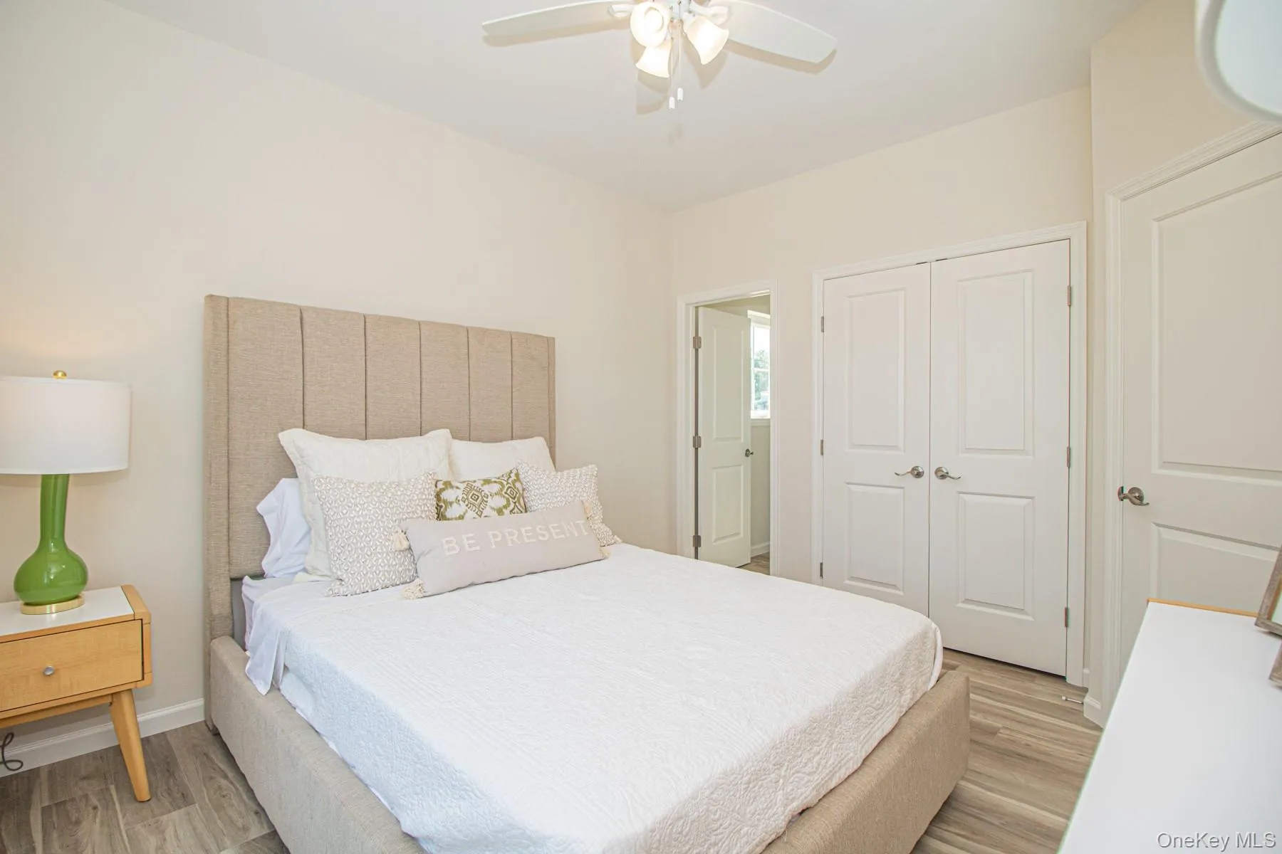 Bedroom featuring light wood finished floors, ceiling fan, and a closet Bedroom featuring light wood finished floors, ceiling fan, and a closet