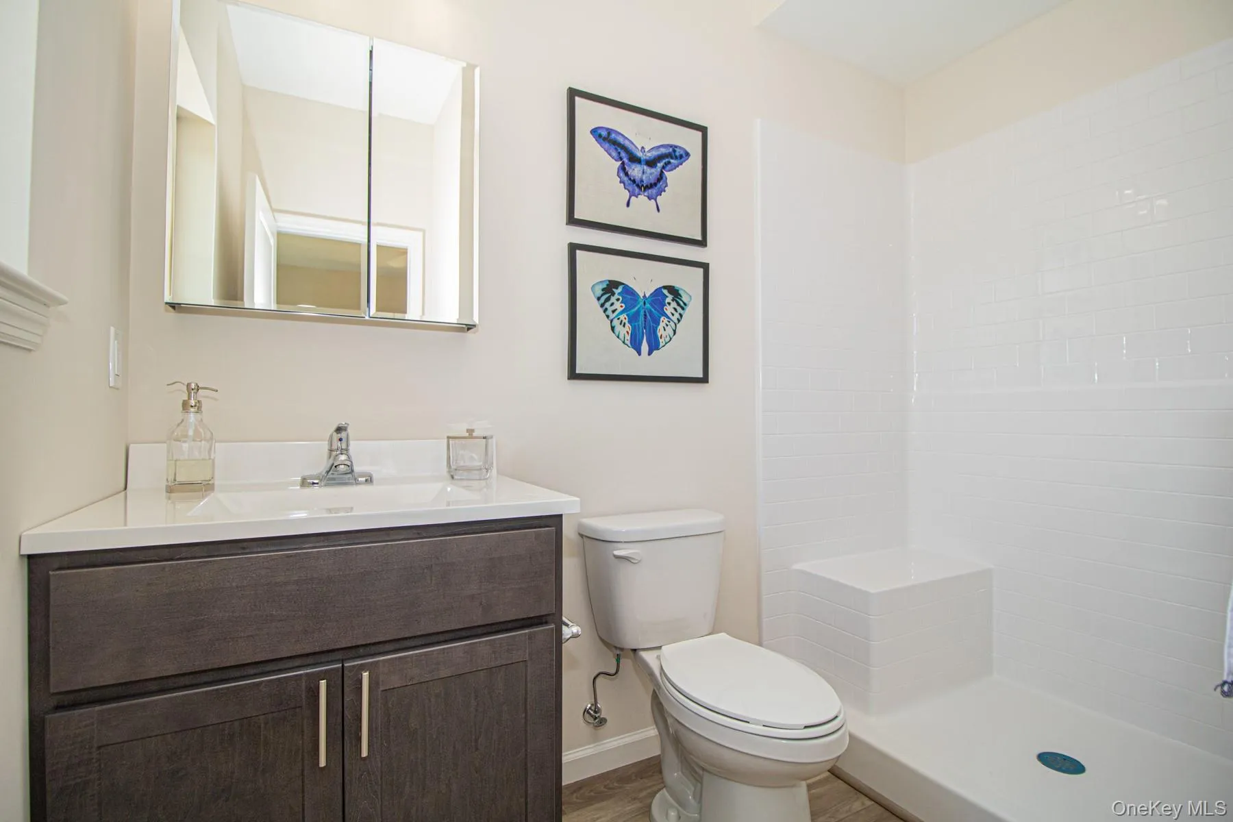 Full bath with vanity, a shower, and dark wood-style floors Full bath with vanity, a shower, and dark wood-style floors