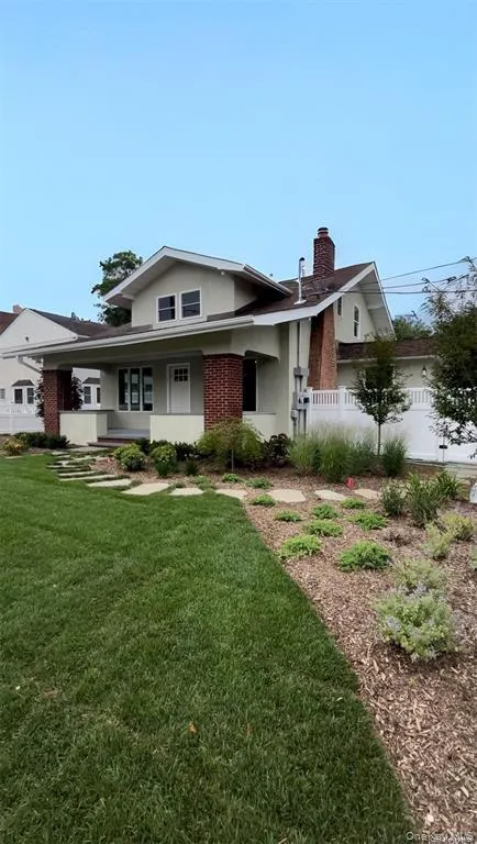 Bungalow-style home featuring a chimney, brick siding, and a porch Bungalow-style home featuring a chimney, brick siding, and a porch