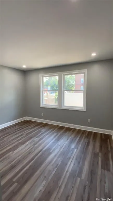 Unfurnished room with dark wood-style floors and recessed lighting Unfurnished room with dark wood-style floors and recessed lighting