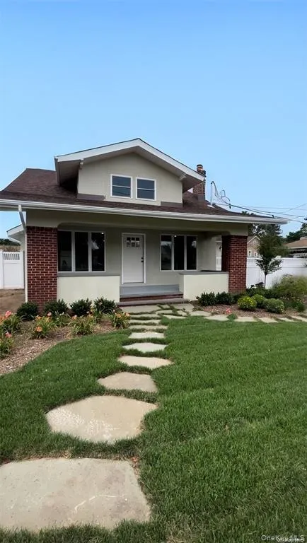 View of front of property featuring covered porch, brick siding, and stucco siding View of front of property featuring covered porch, brick siding, and stucco siding
