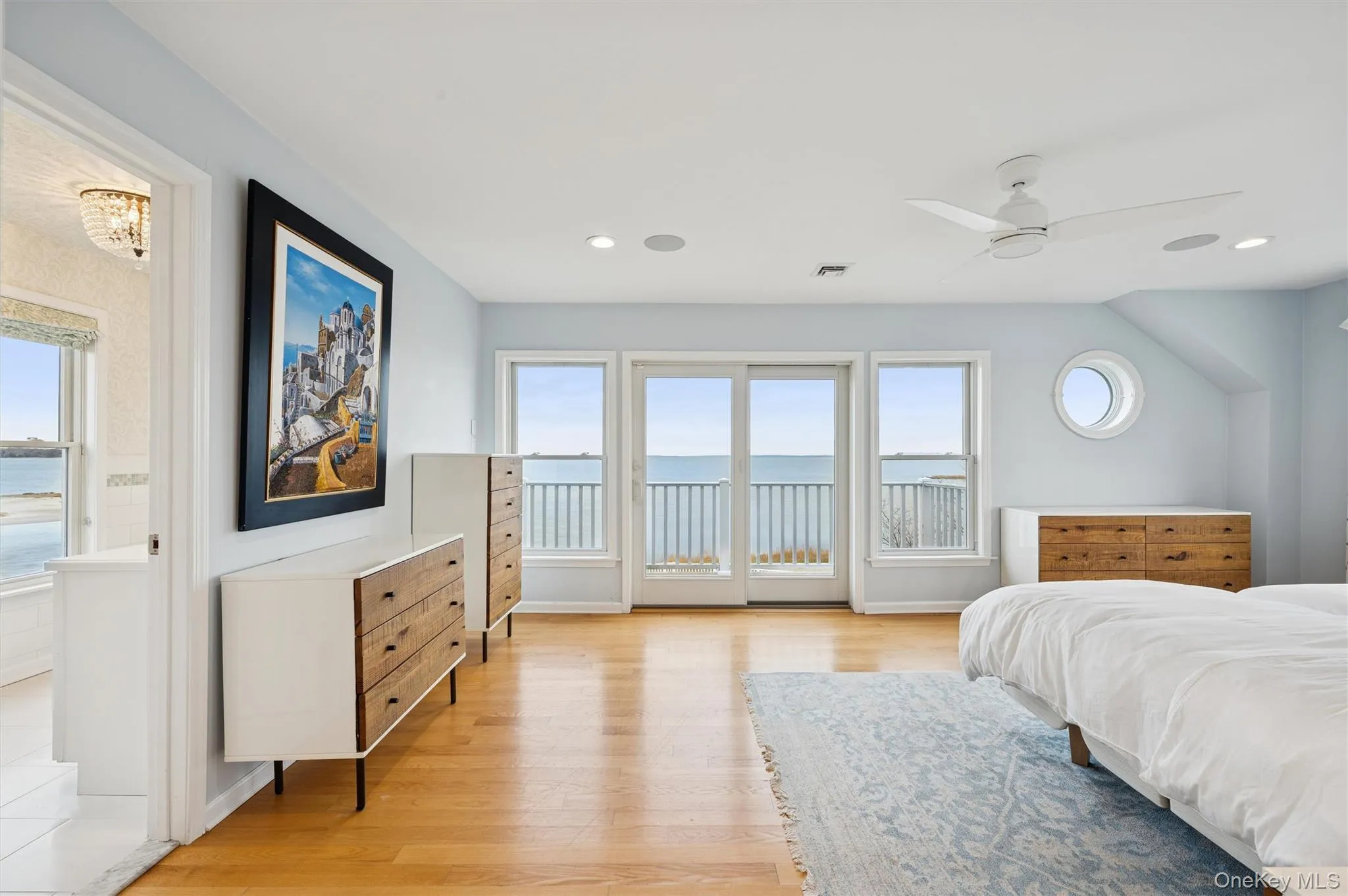 Bedroom with a water view, access to outside, light wood finished floors, a ceiling fan, and recessed lighting Bedroom with a water view, access to outside, light wood finished floors, a ceiling fan, and recessed lighting