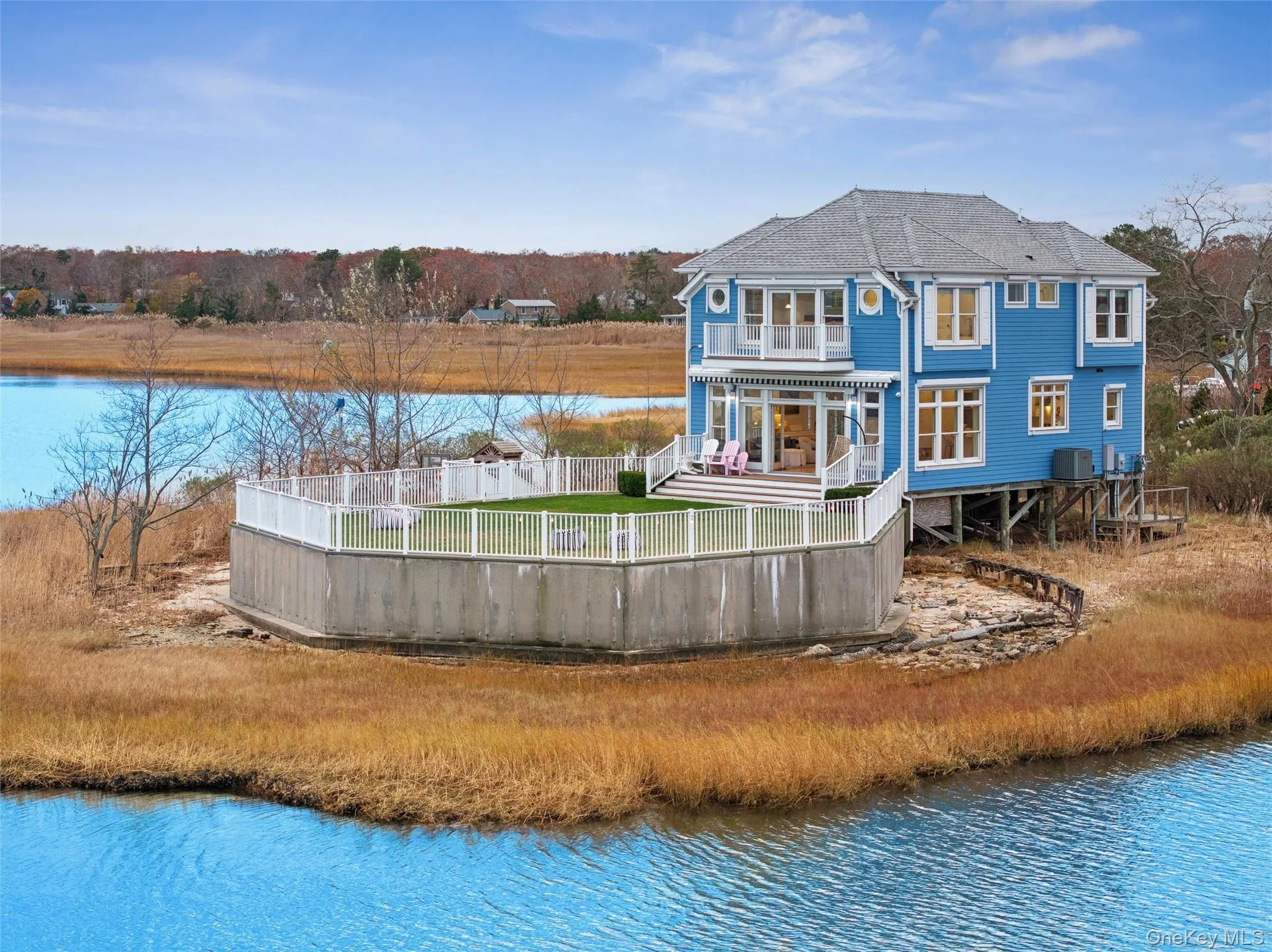 Back of house featuring a deck with water view and a patio area Back of house featuring a deck with water view and a patio area