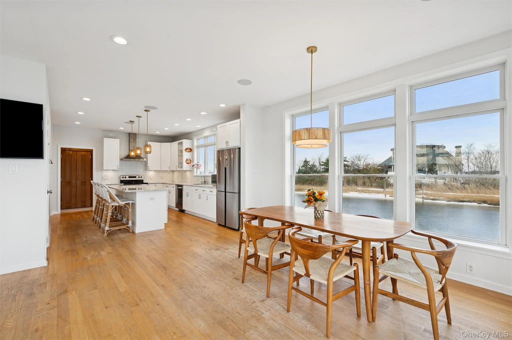 Dining space with recessed lighting, light wood-type flooring, and a water view Dining space with recessed lighting, light wood-type flooring, and a water view