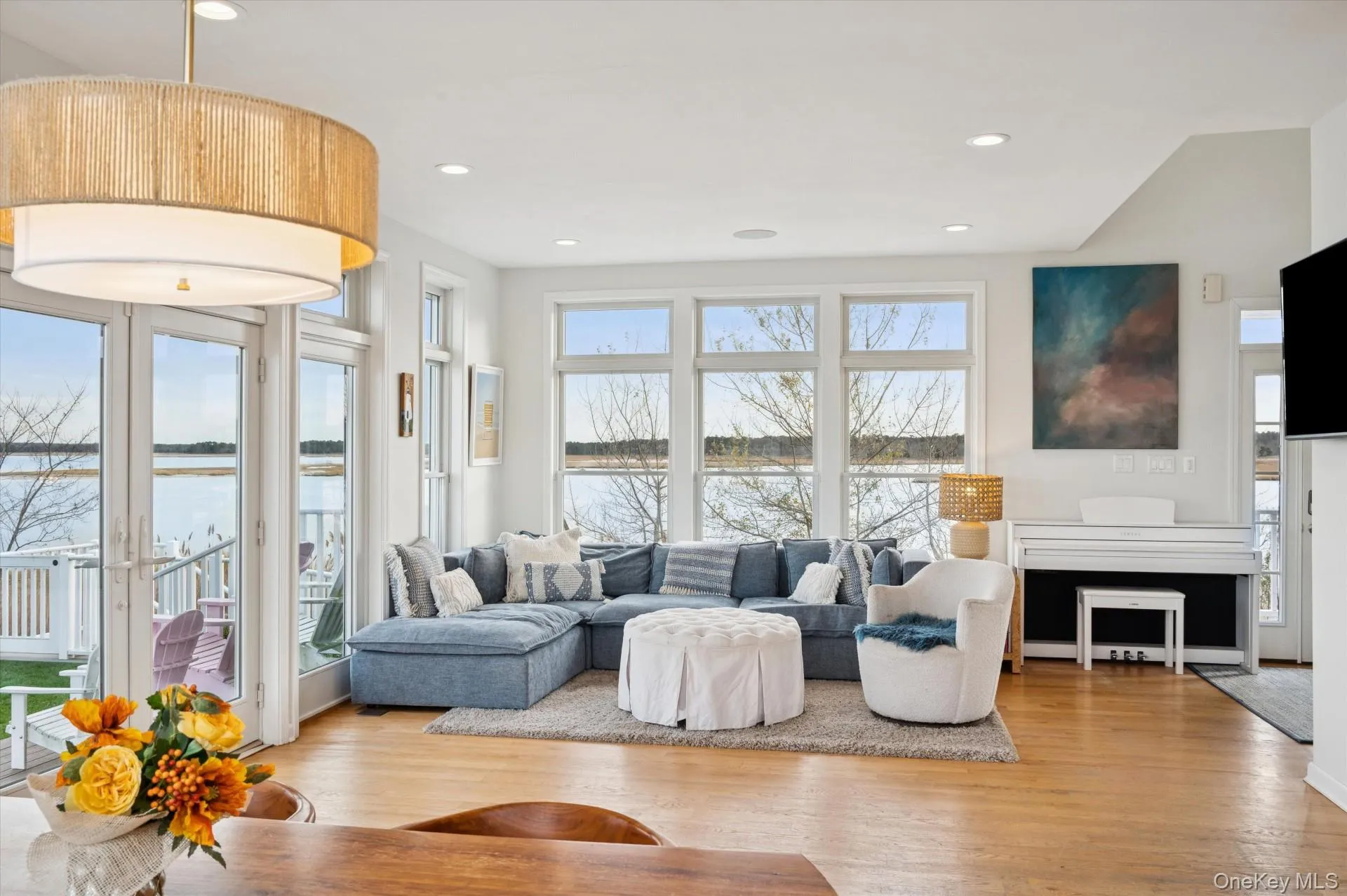 Living room featuring a water view, light wood-style flooring, plenty of natural light, and recessed lighting Living room featuring a water view, light wood-style flooring, plenty of natural light, and recessed lighting