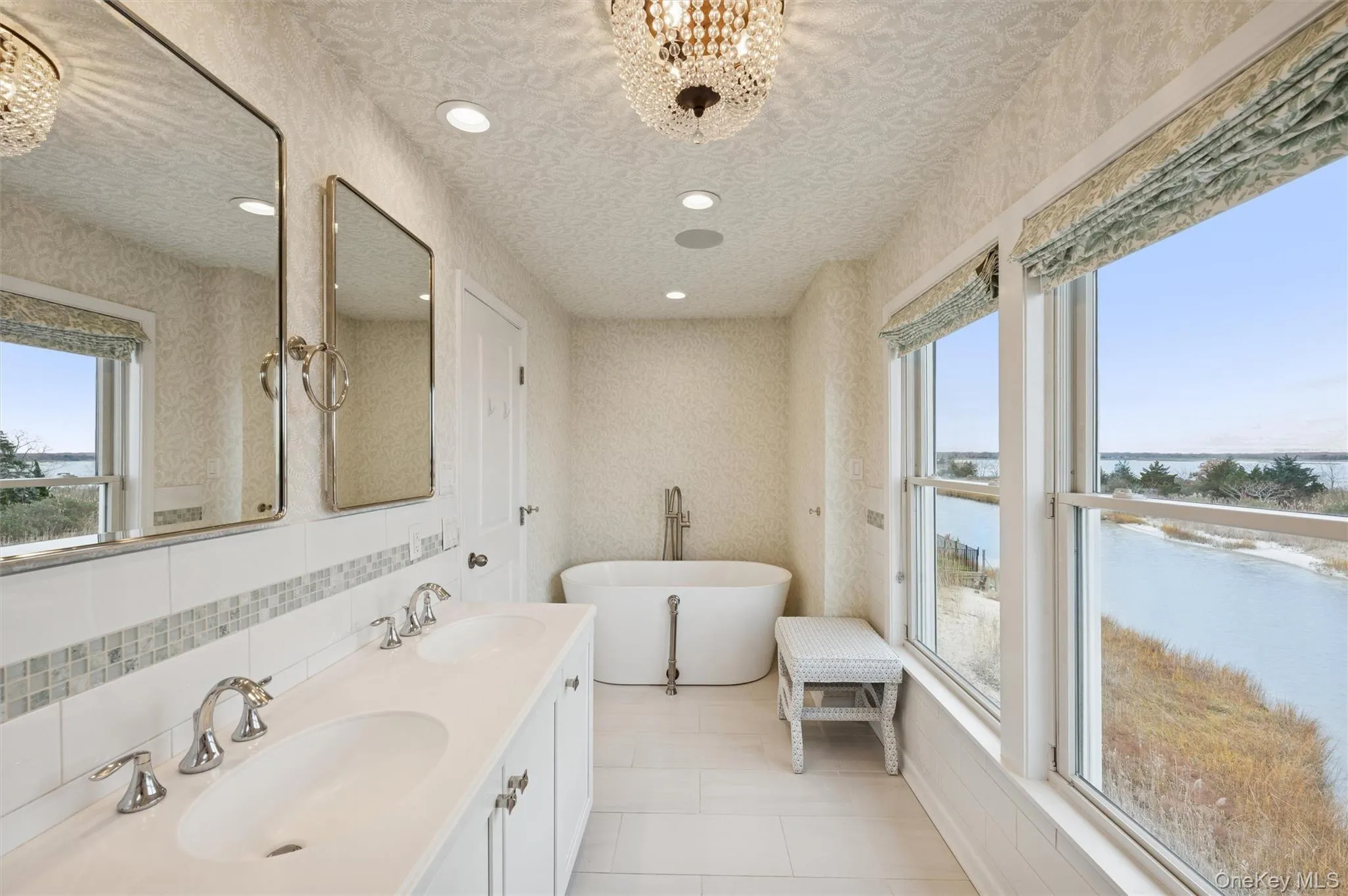Bathroom with a chandelier, a freestanding tub, wallpapered walls, double vanity, and recessed lighting Bathroom with a chandelier, a freestanding tub, wallpapered walls, double vanity, and recessed lighting