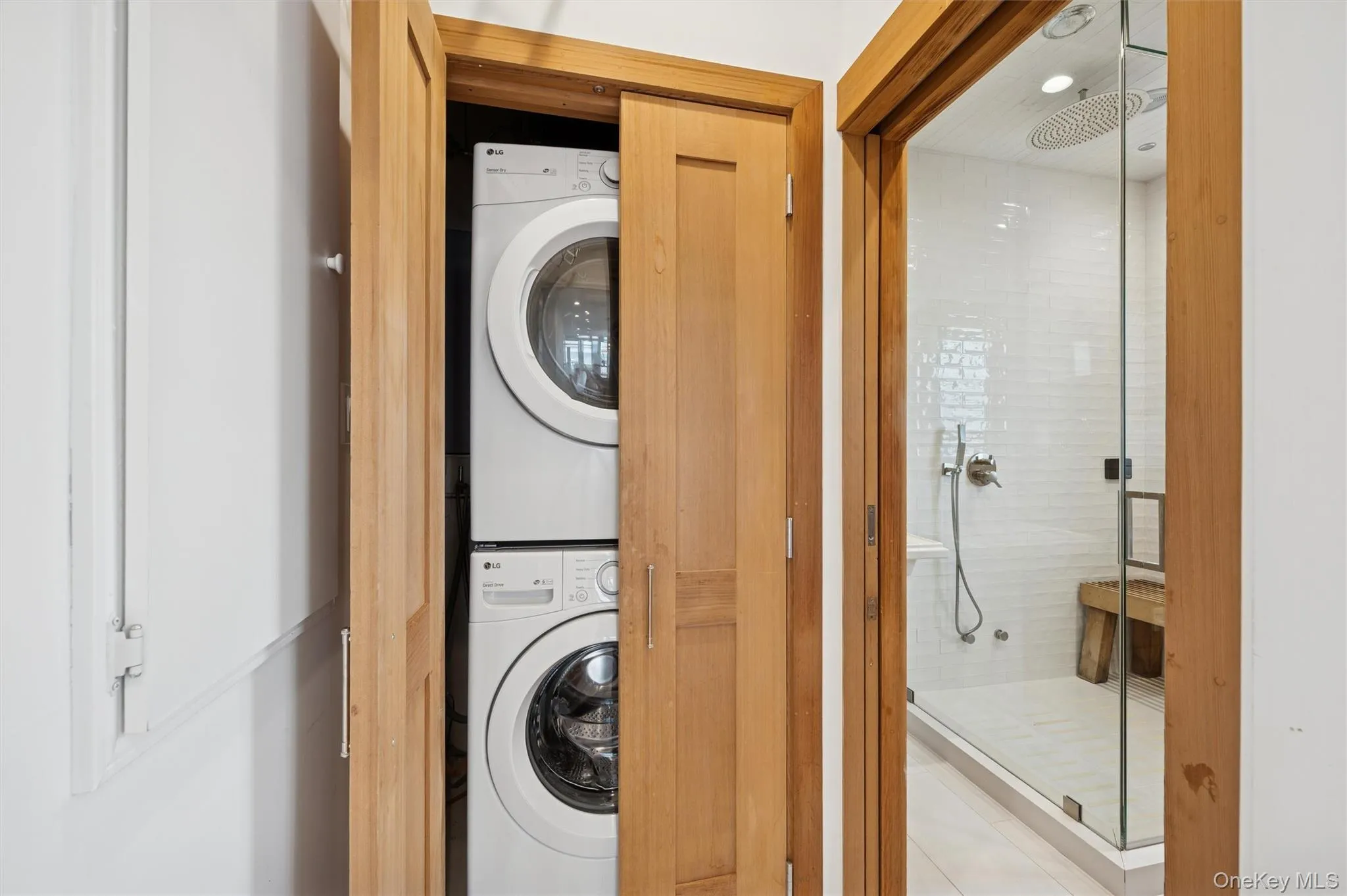 Laundry area with stacked washer and clothes dryer and recessed lighting Laundry area with stacked washer and clothes dryer and recessed lighting