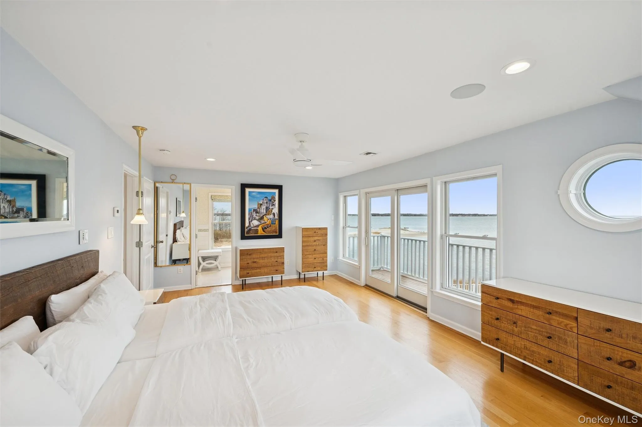 Bedroom featuring access to exterior, light wood finished floors, recessed lighting, ceiling fan, and a water view Bedroom featuring access to exterior, light wood finished floors, recessed lighting, ceiling fan, and a water view