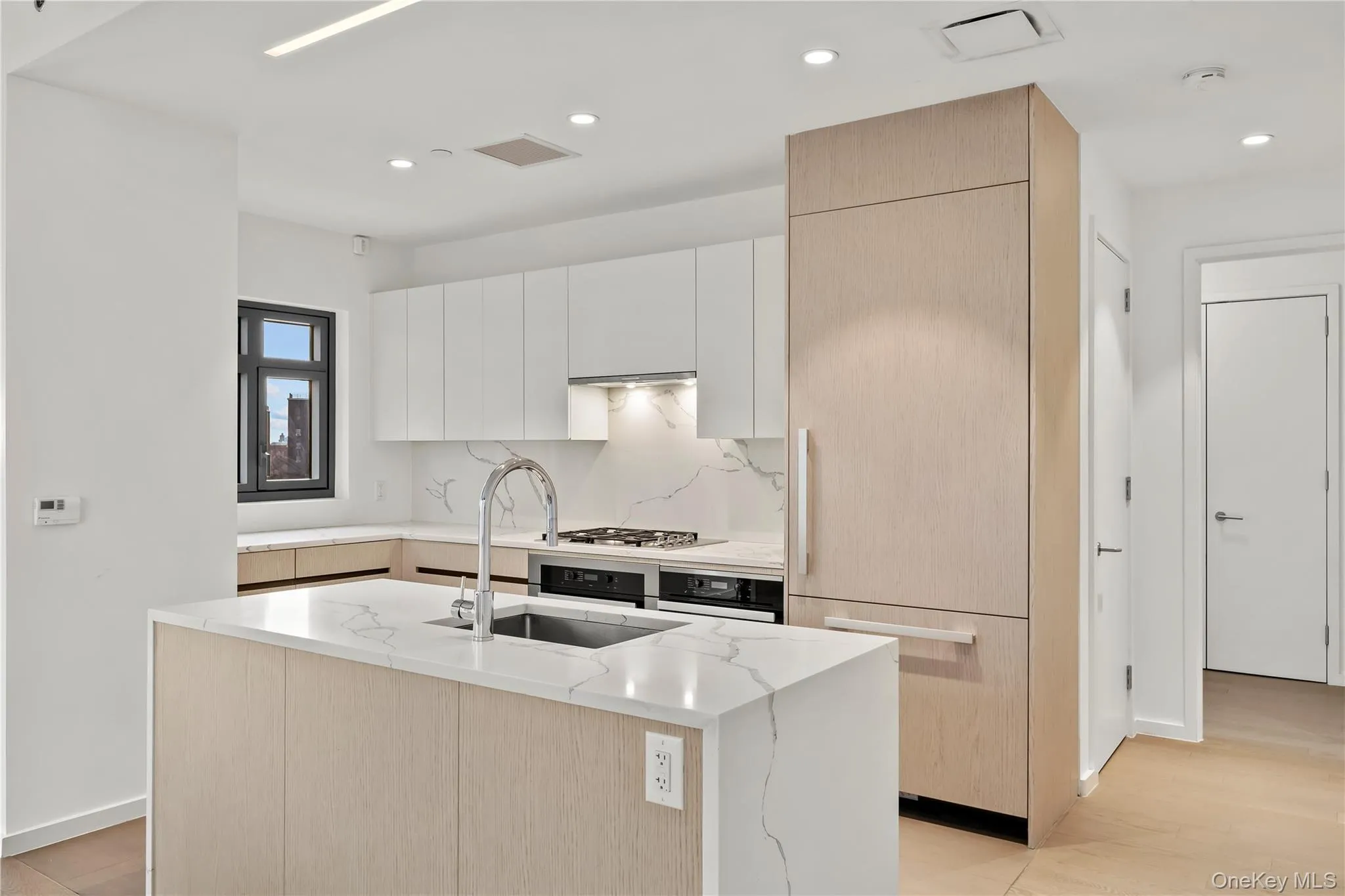 Kitchen with light brown cabinets, white cabinets, modern cabinets, light stone counters, and recessed lighting Kitchen with light brown cabinets, white cabinets, modern cabinets, light stone counters, and recessed lighting