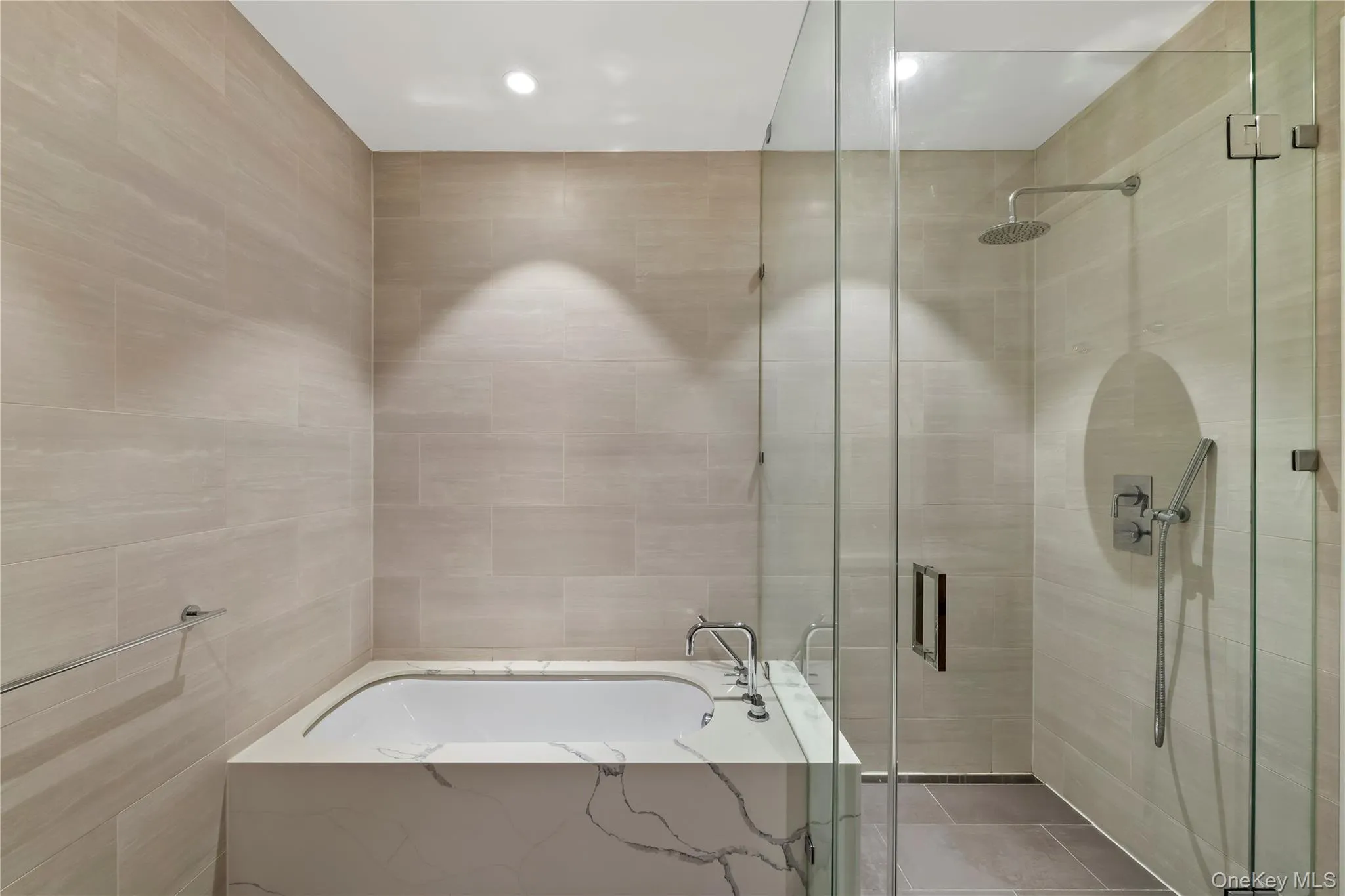 Full bathroom with a bath, a stall shower, and tile walls Full bathroom with a bath, a stall shower, and tile walls