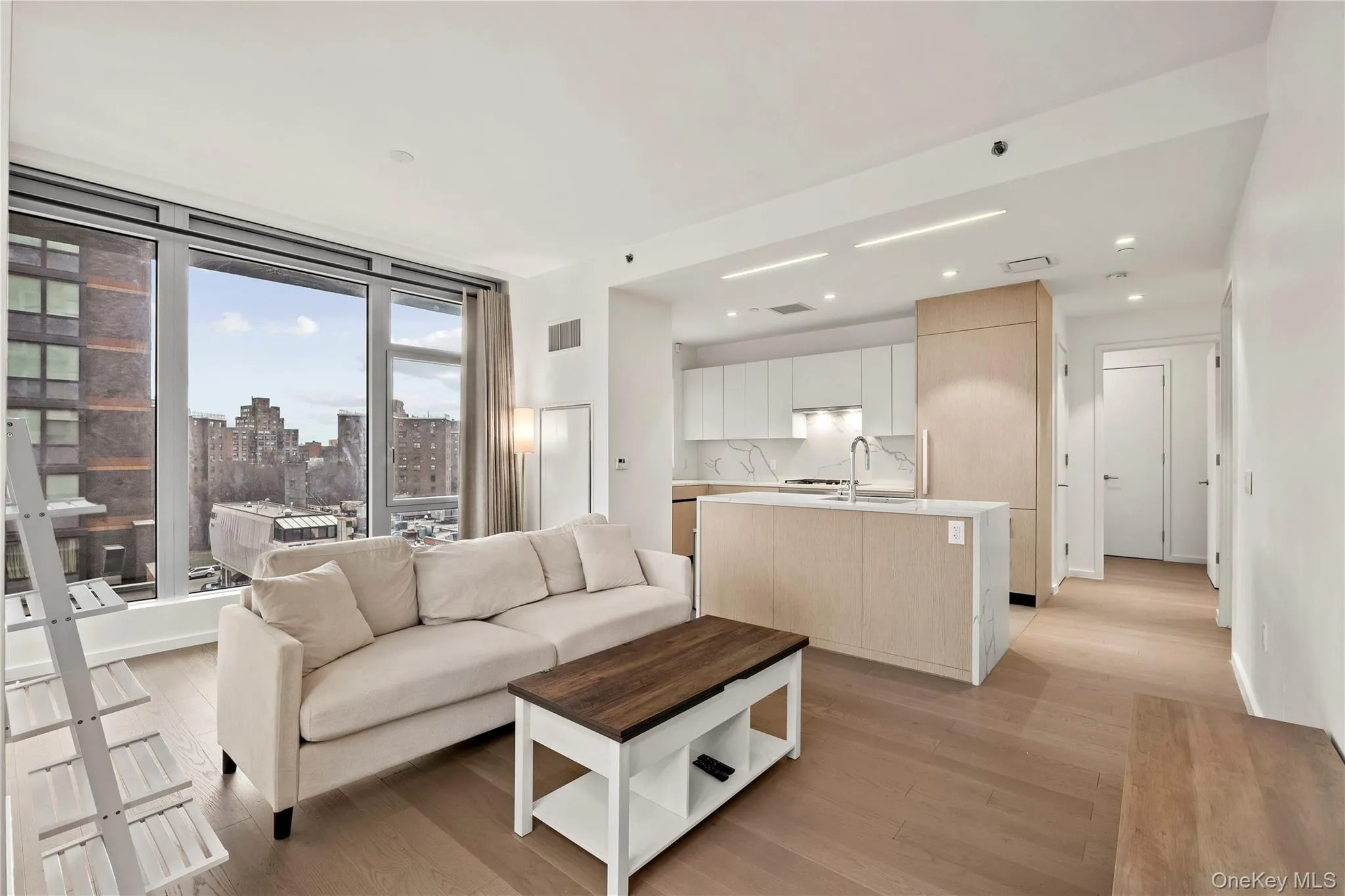 Living room featuring light wood-type flooring, a view of city, and recessed lighting Living room featuring light wood-type flooring, a view of city, and recessed lighting