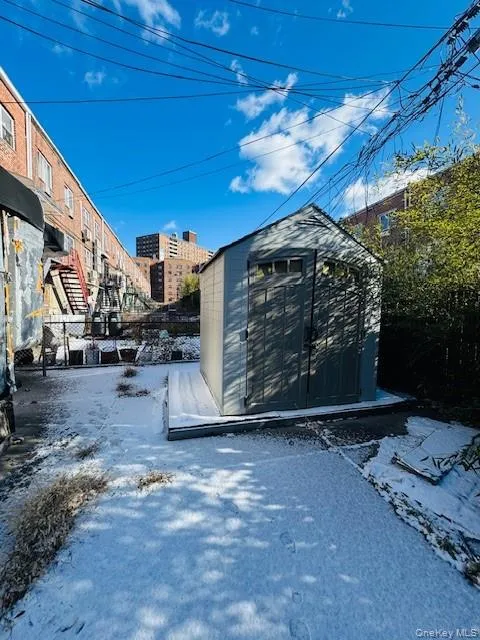 Snow covered gate featuring a storage unit Snow covered gate featuring a storage unit