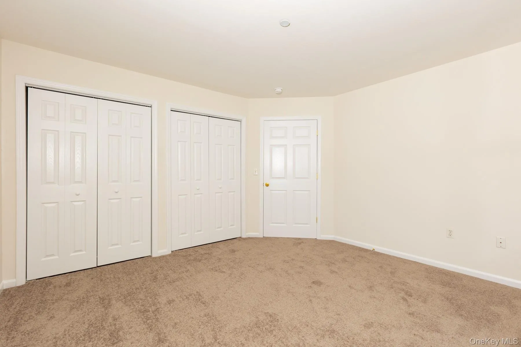 Unfurnished bedroom with two closets and carpet Unfurnished bedroom with two closets and carpet