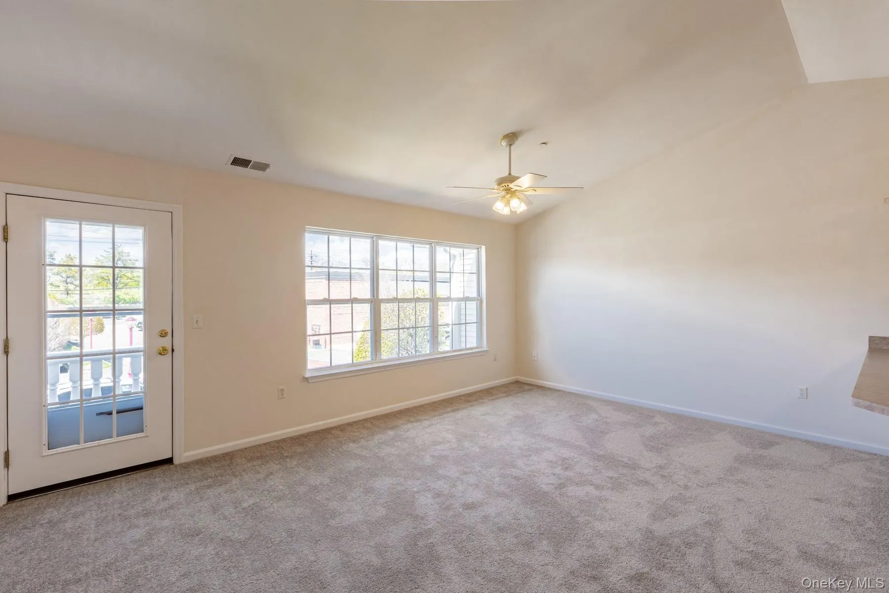 Unfurnished room featuring vaulted ceiling, carpet, and a ceiling fan Unfurnished room featuring vaulted ceiling, carpet, and a ceiling fan