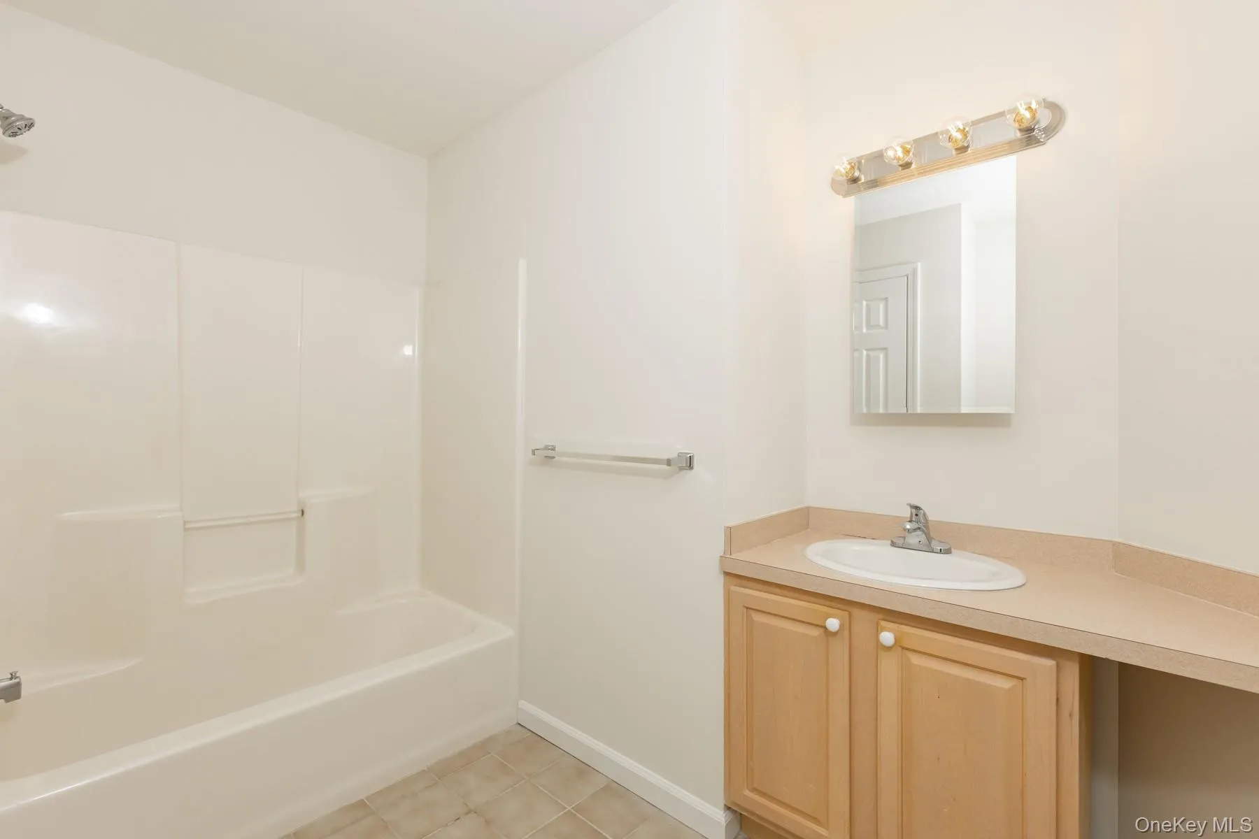 Bathroom with vanity, shower / bath combination, and light tile patterned floors Bathroom with vanity, shower / bath combination, and light tile patterned floors