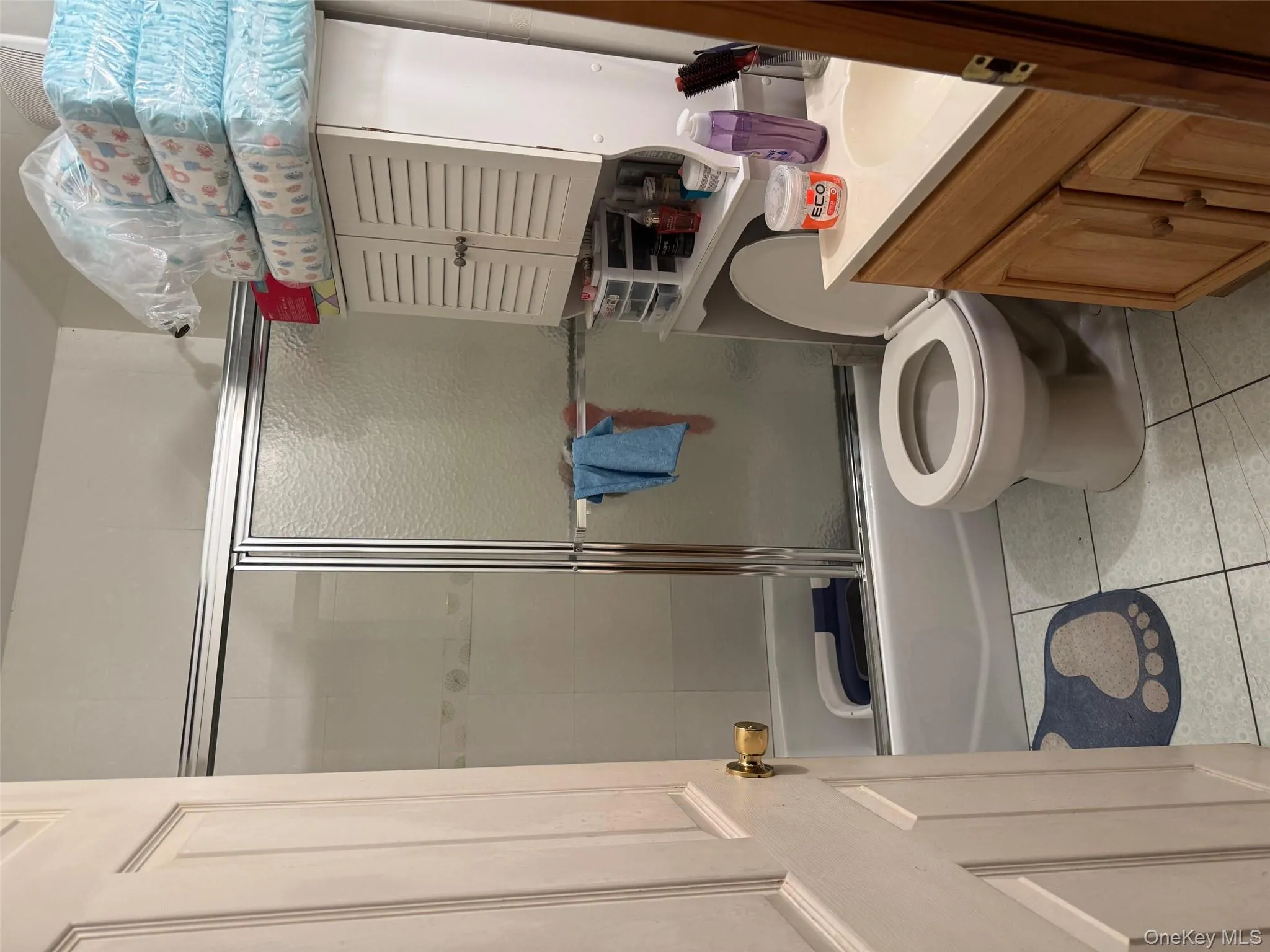 Bathroom with vanity, shower / bath combination with glass door, and light tile patterned flooring Bathroom with vanity, shower / bath combination with glass door, and light tile patterned flooring