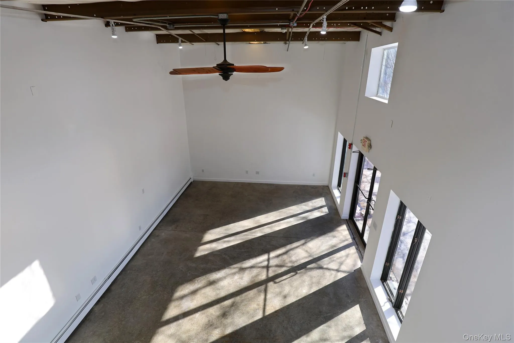 Basement featuring baseboard heating, ceiling fan, and carpet floors Basement featuring baseboard heating, ceiling fan, and carpet floors