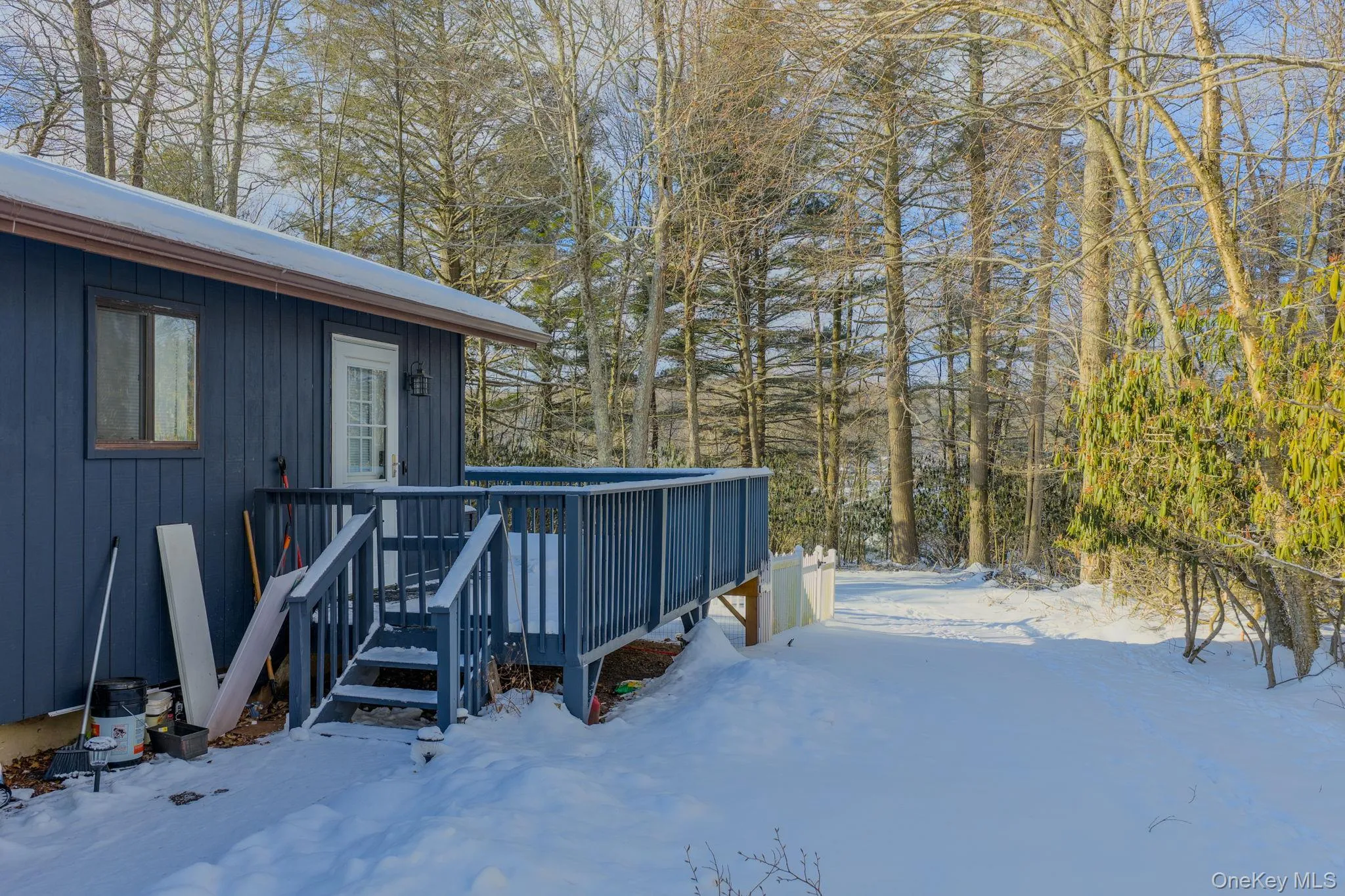 Yard layered in snow with a wooden deck Yard layered in snow with a wooden deck