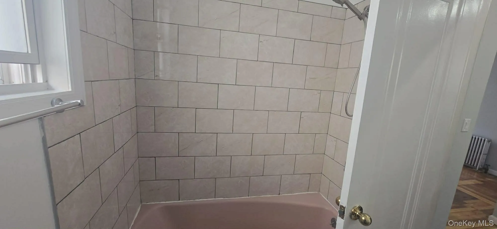 Full bathroom with radiator heating unit and shower / washtub combination Full bathroom with radiator heating unit and shower / washtub combination