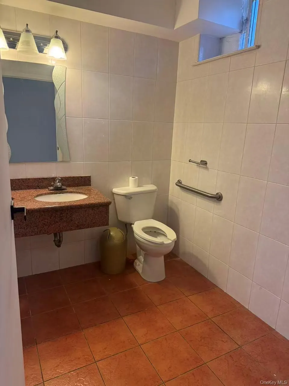 Half bath with tile patterned floors, tile walls, and vanity Half bath with tile patterned floors, tile walls, and vanity