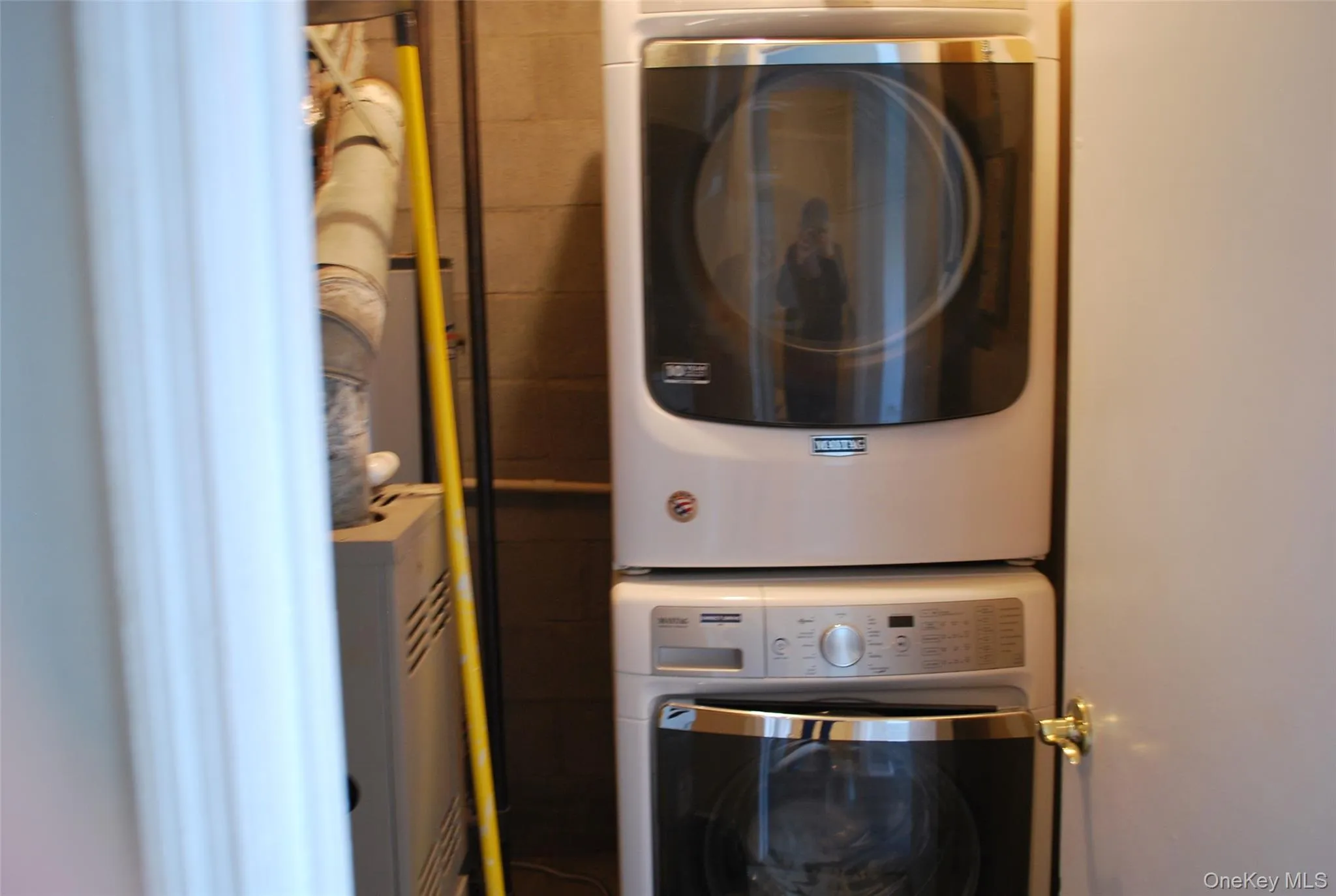 Laundry room featuring stacked washer / dryer Laundry room featuring stacked washer / dryer