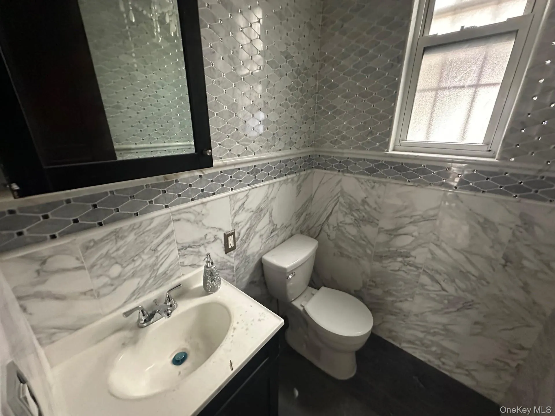 Half bath featuring vanity and tile walls Half bath featuring vanity and tile walls