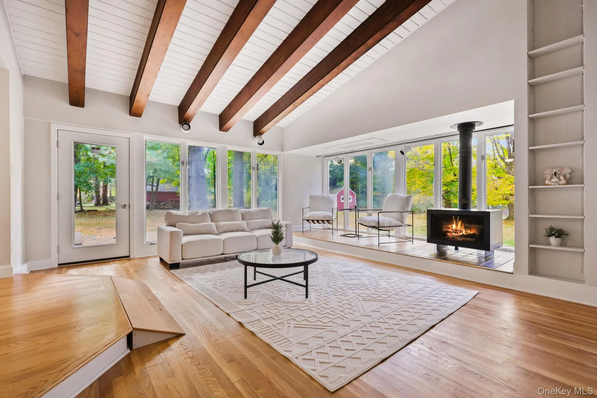 Living room with built in features, healthy amount of natural light, hardwood / wood-style flooring, high vaulted ceiling, and beamed ceiling Living room with built in features, healthy amount of natural light, hardwood / wood-style flooring, high vaulted ceiling, and beamed ceiling