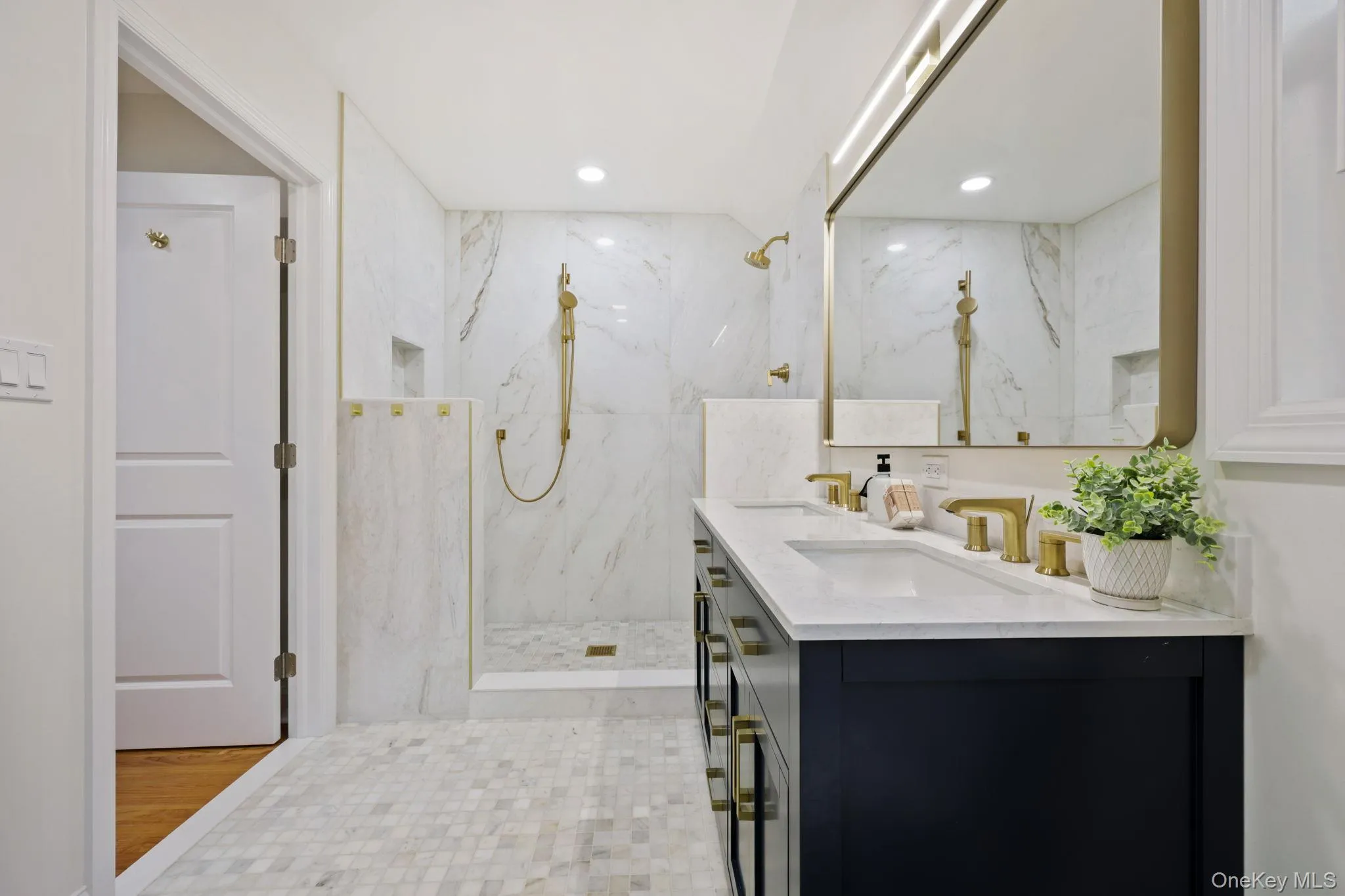 Full bathroom featuring double vanity, a marble finish shower, and recessed lighting Full bathroom featuring double vanity, a marble finish shower, and recessed lighting