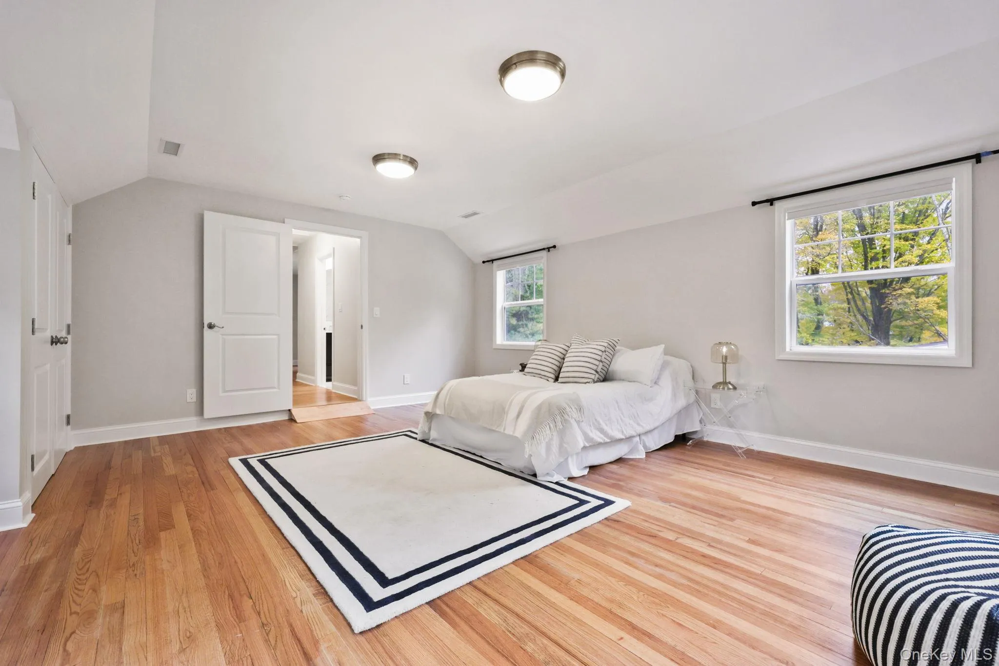 Bedroom with light wood-type flooring and lofted ceiling Bedroom with light wood-type flooring and lofted ceiling