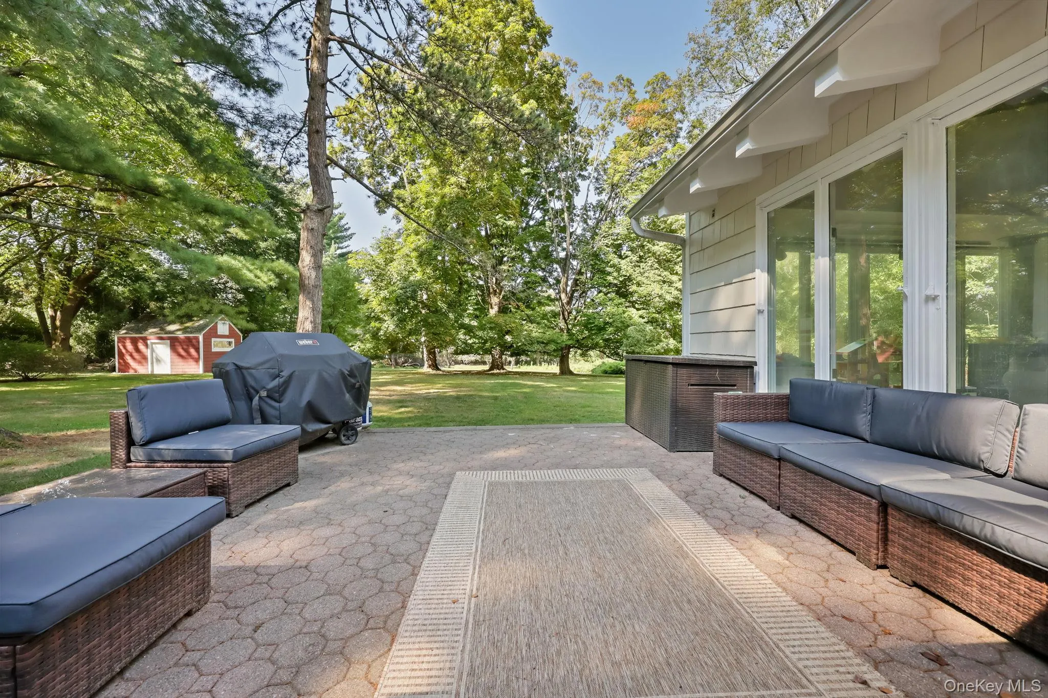 View of patio / terrace featuring a grill, an outdoor hangout area, a shed, and view of wooded area View of patio / terrace featuring a grill, an outdoor hangout area, a shed, and view of wooded area