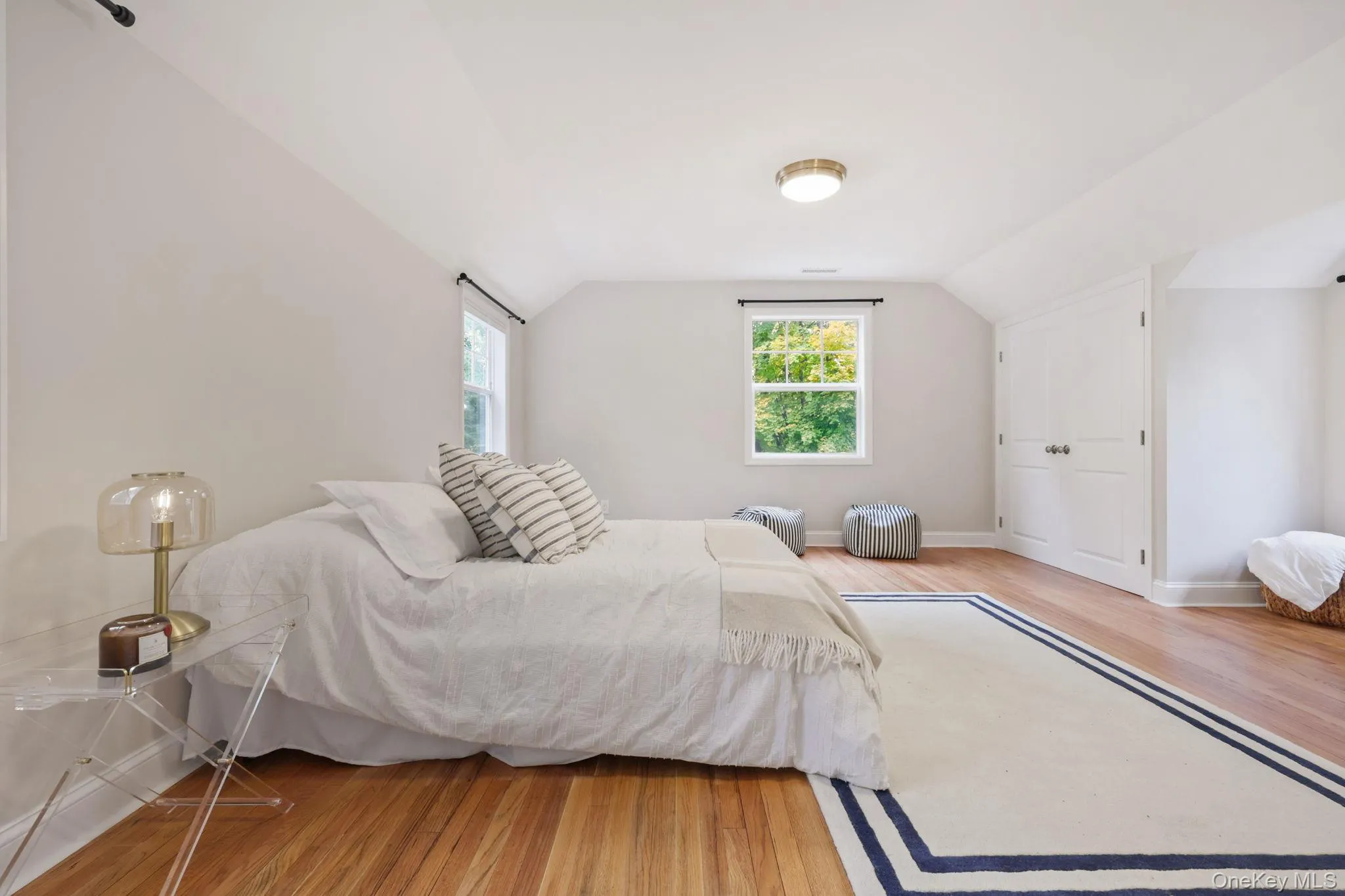 Bedroom featuring light wood-type flooring, vaulted ceiling, and radiator Bedroom featuring light wood-type flooring, vaulted ceiling, and radiator