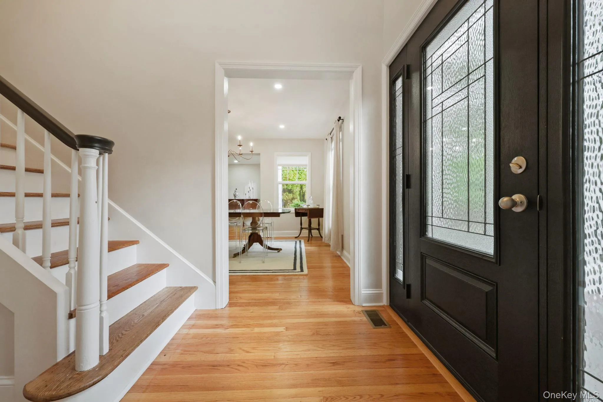 Foyer with stairs, light wood finished floors, a chandelier, and recessed lighting Foyer with stairs, light wood finished floors, a chandelier, and recessed lighting