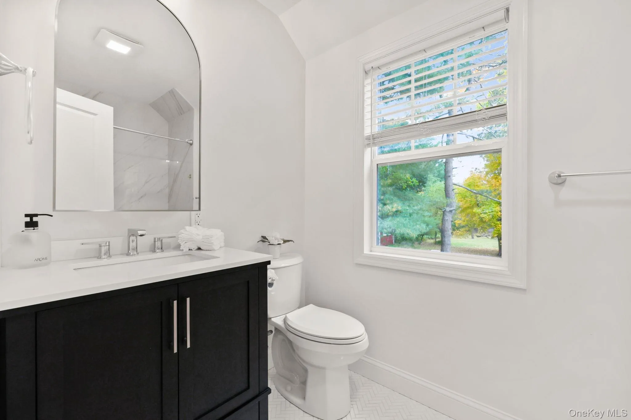 Full bathroom with a marble finish shower, vanity, and lofted ceiling Full bathroom with a marble finish shower, vanity, and lofted ceiling