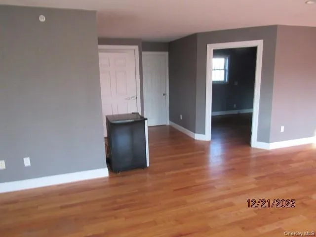 Spare room with baseboards and light wood-style flooring Spare room with baseboards and light wood-style flooring